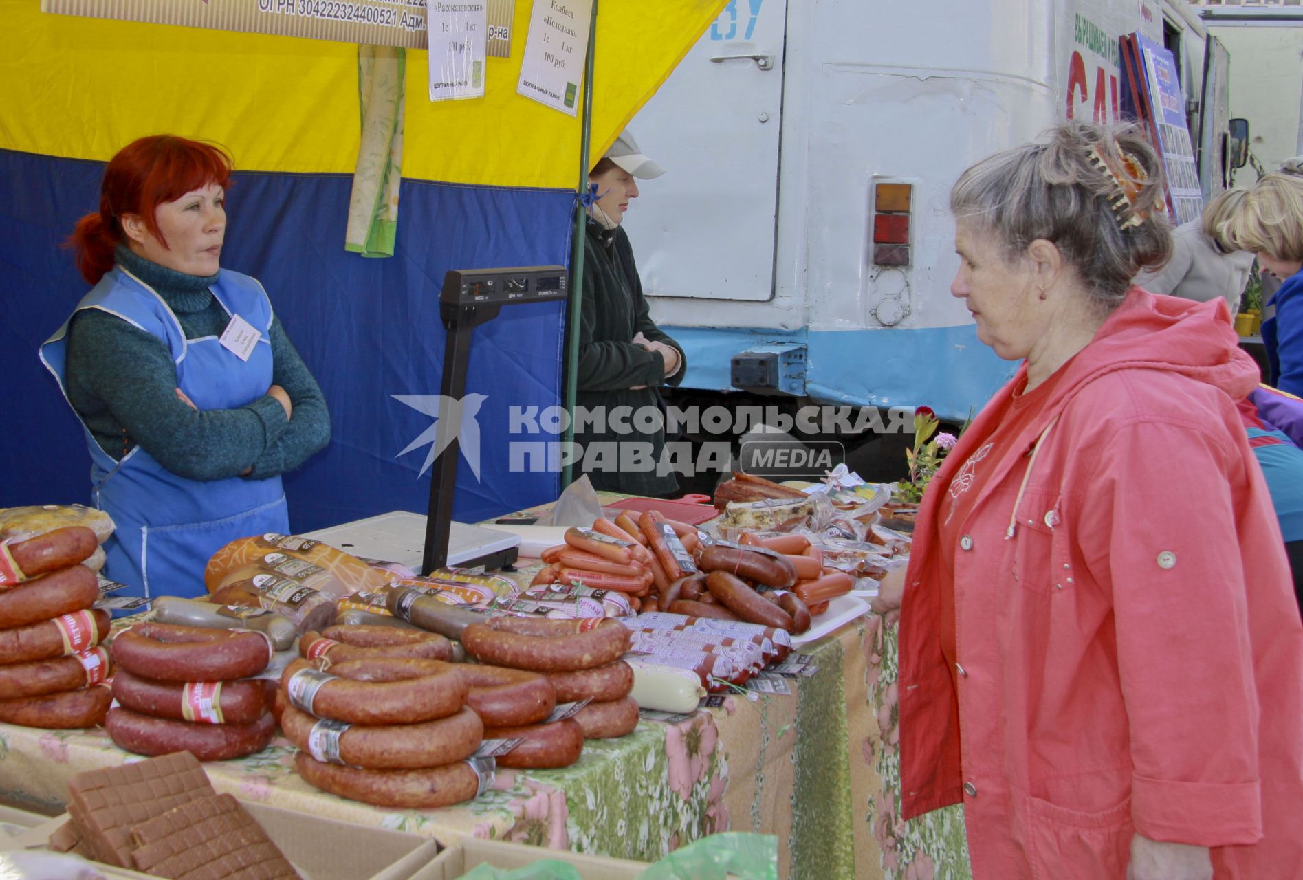 Продажа колбасы на рынке. Покупатель выбирает товар.