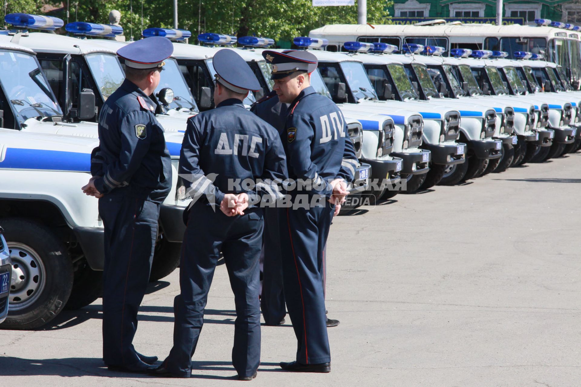 Открытый общегородской развод полицейских нарядов. Сотрудники ДПС на фоне большого количества служебных полицейских автомобилей УАЗ.