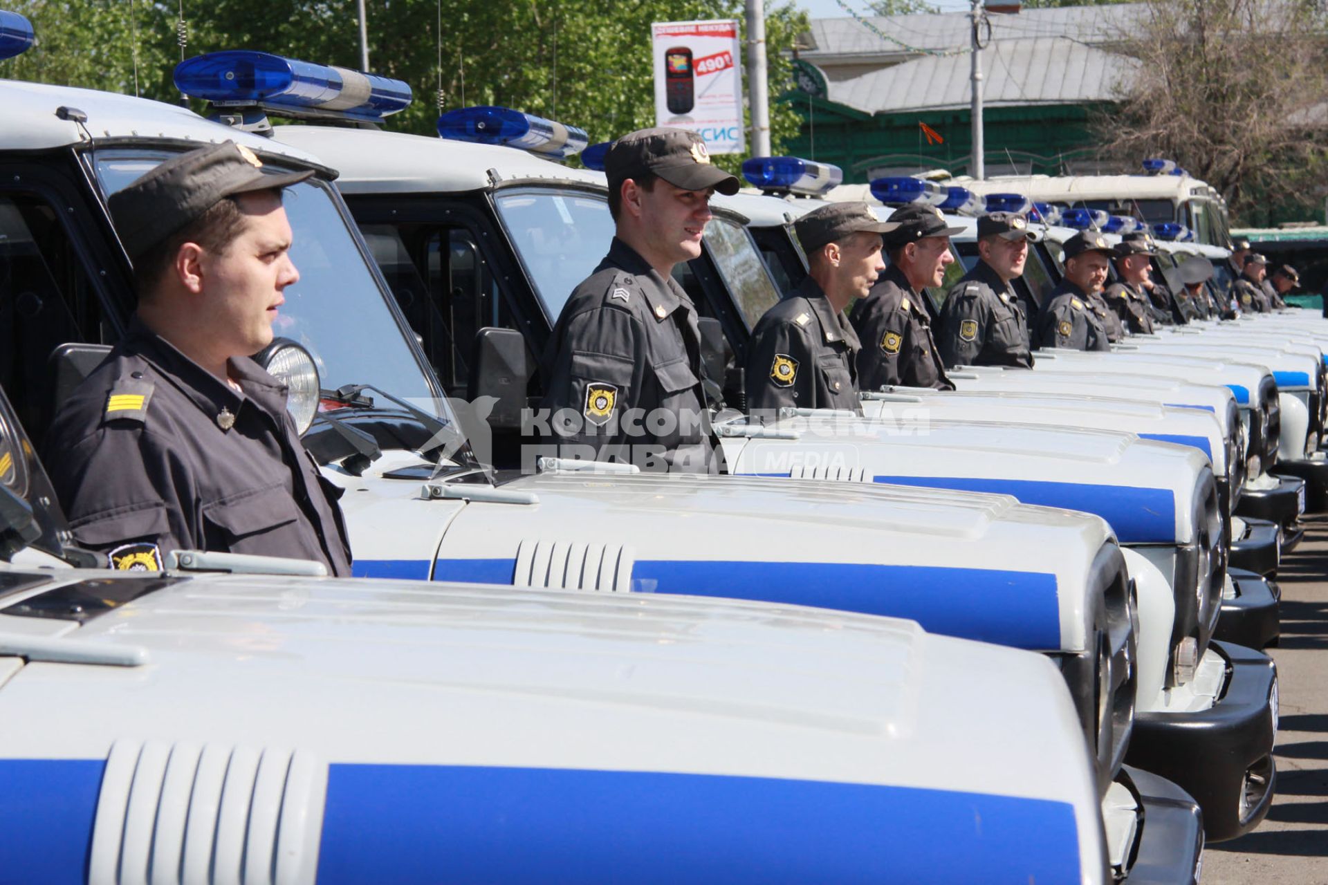 Открытый общегородской развод полицейских нарядов. Сотрудники ДПС на фоне большого количества служебных полицейских автомобилей УАЗ.