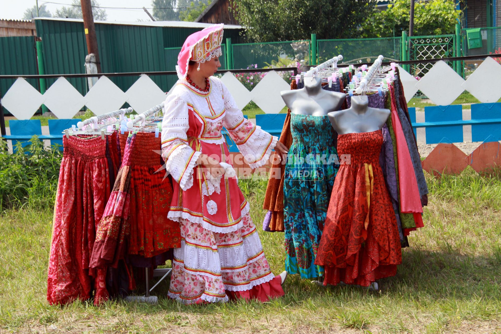На фестивале имени Михаила Евдокимова. Женщина в народном костюме выбирает платье.