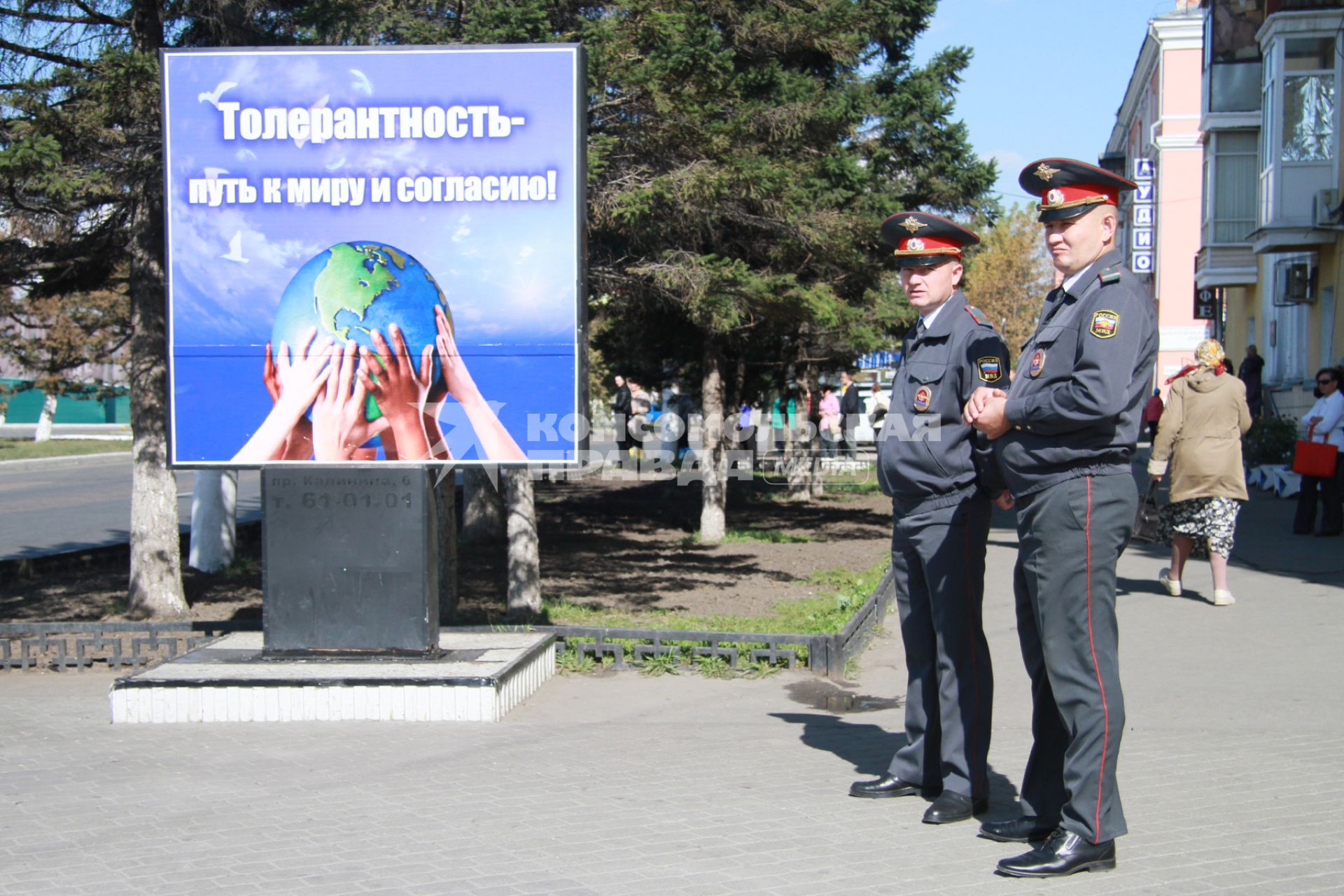 Полицейские у плаката `Толерантность - путь к миру и согласию`