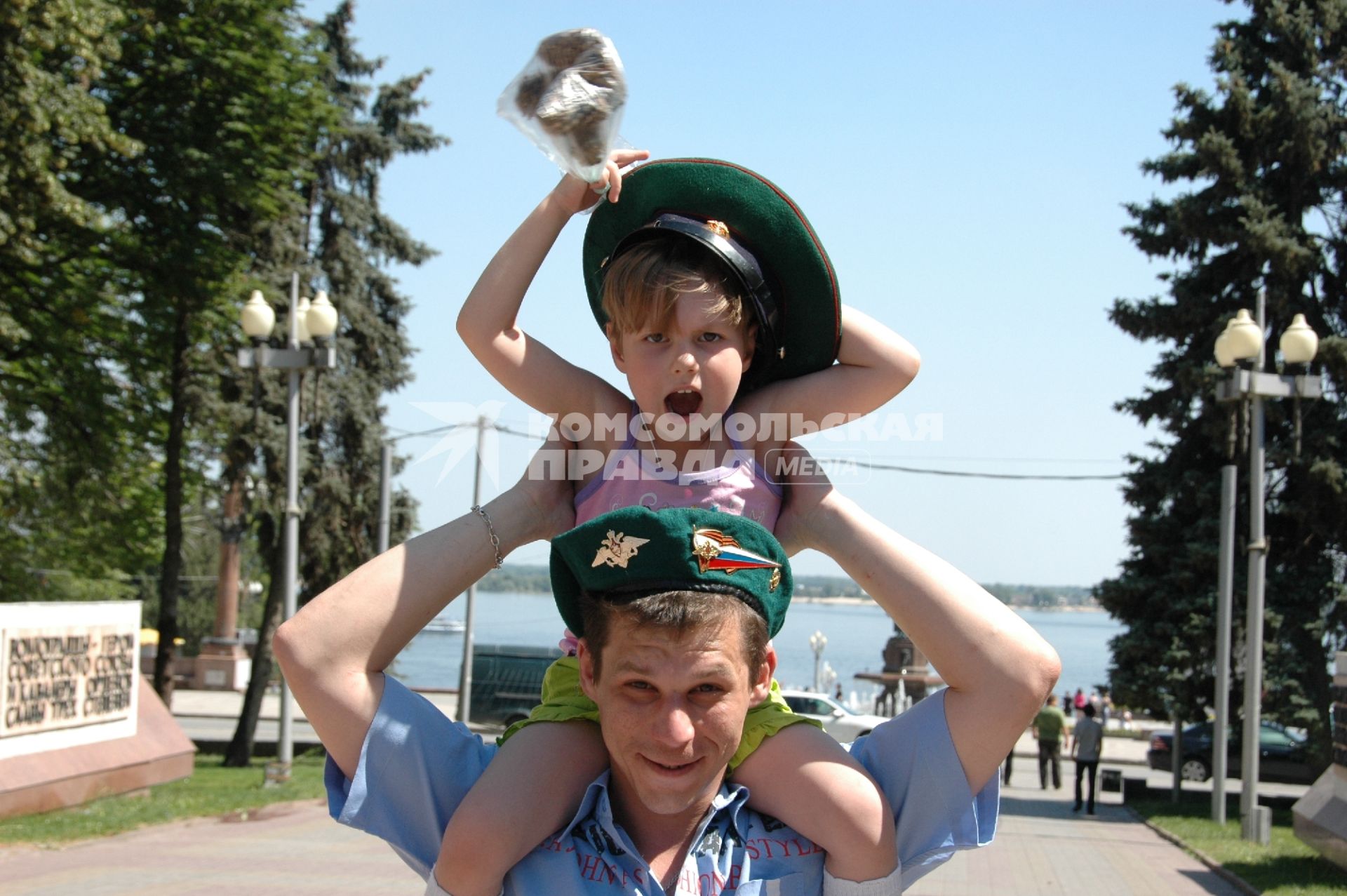 Празднование дня пограничника в Волгограде. На снимке: Мужчина держит на плечах ребенка в фуражке пограничника.