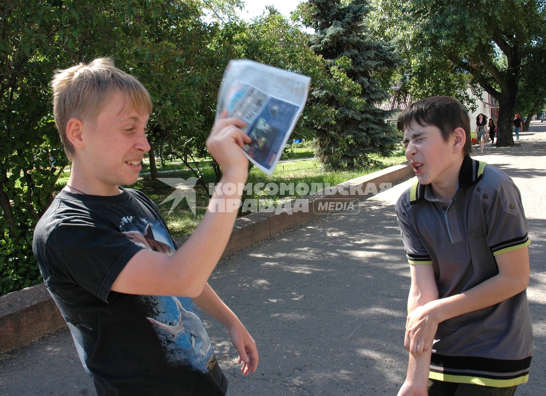 Дети отмахиваются журналами от насекомых.