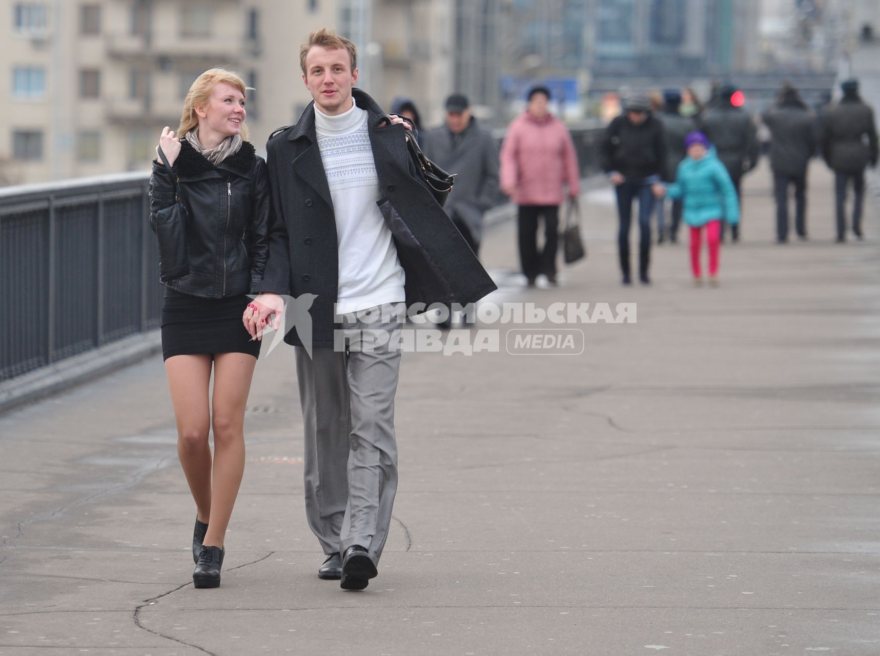 Молодая пара мужчина и женщина прогуливаются по улице города.