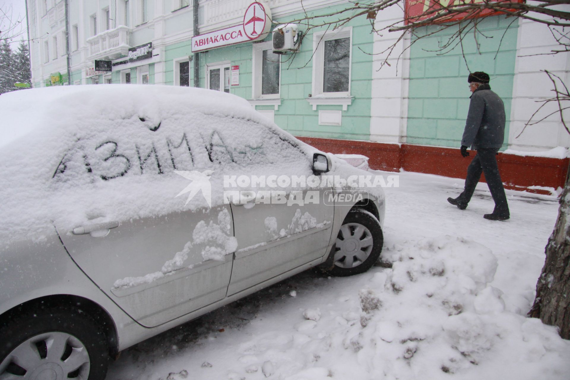 Автомобиль припорошеный снегом с надписью: `зима`.