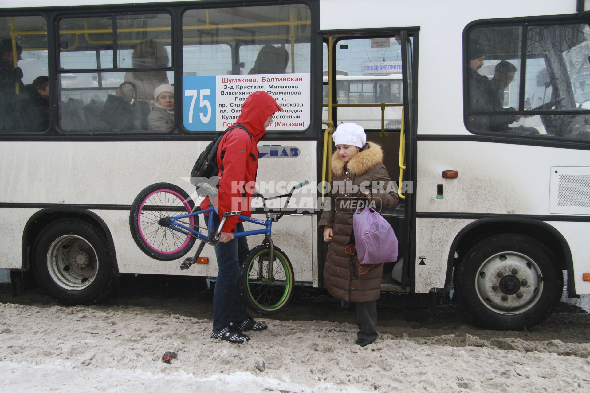 Парень с велосипедом садится в автобус.
