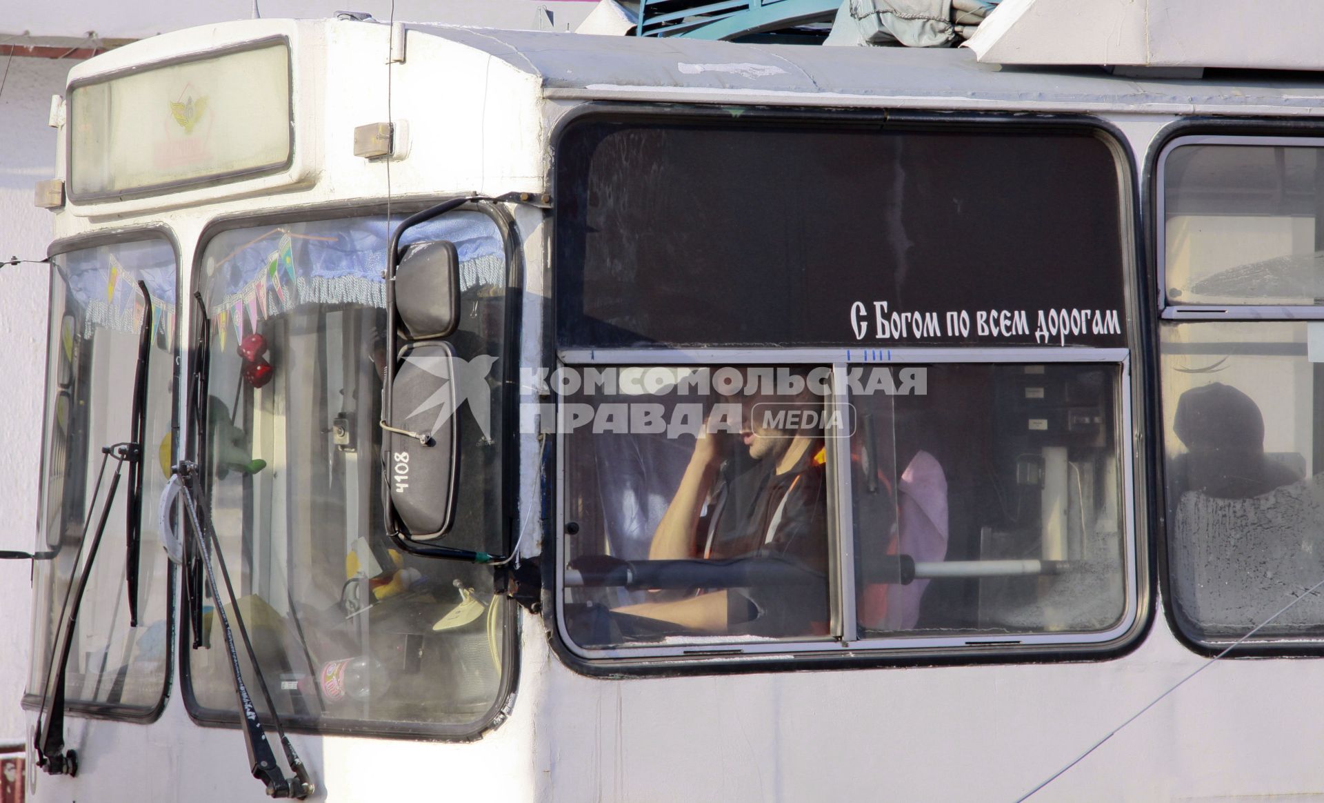 Надпись на кабине водителя троллейбуса `С Богом по всем дорогам`.