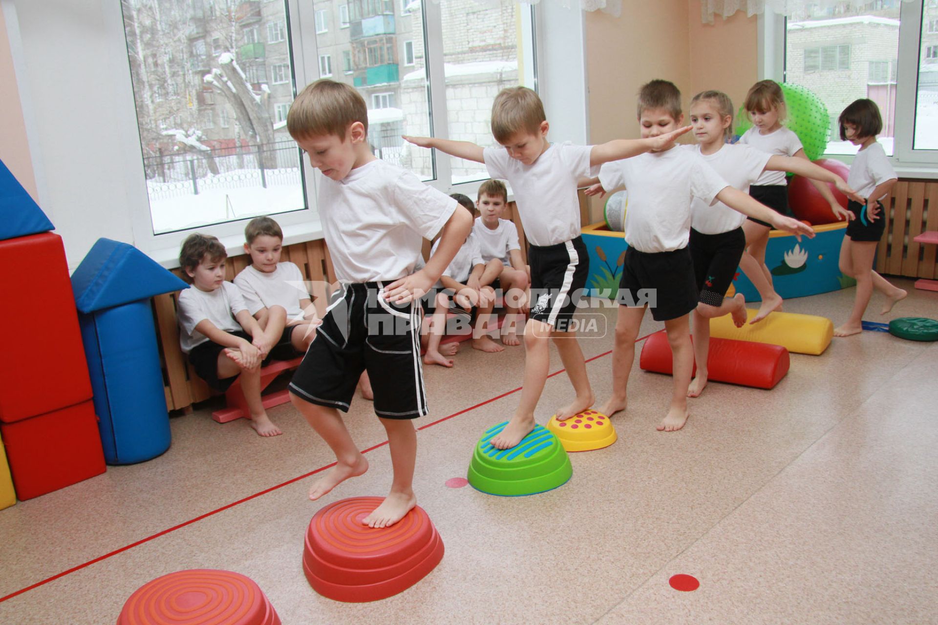 Занятия гимнастикой в детском саду. Дети выполняют упражнения.