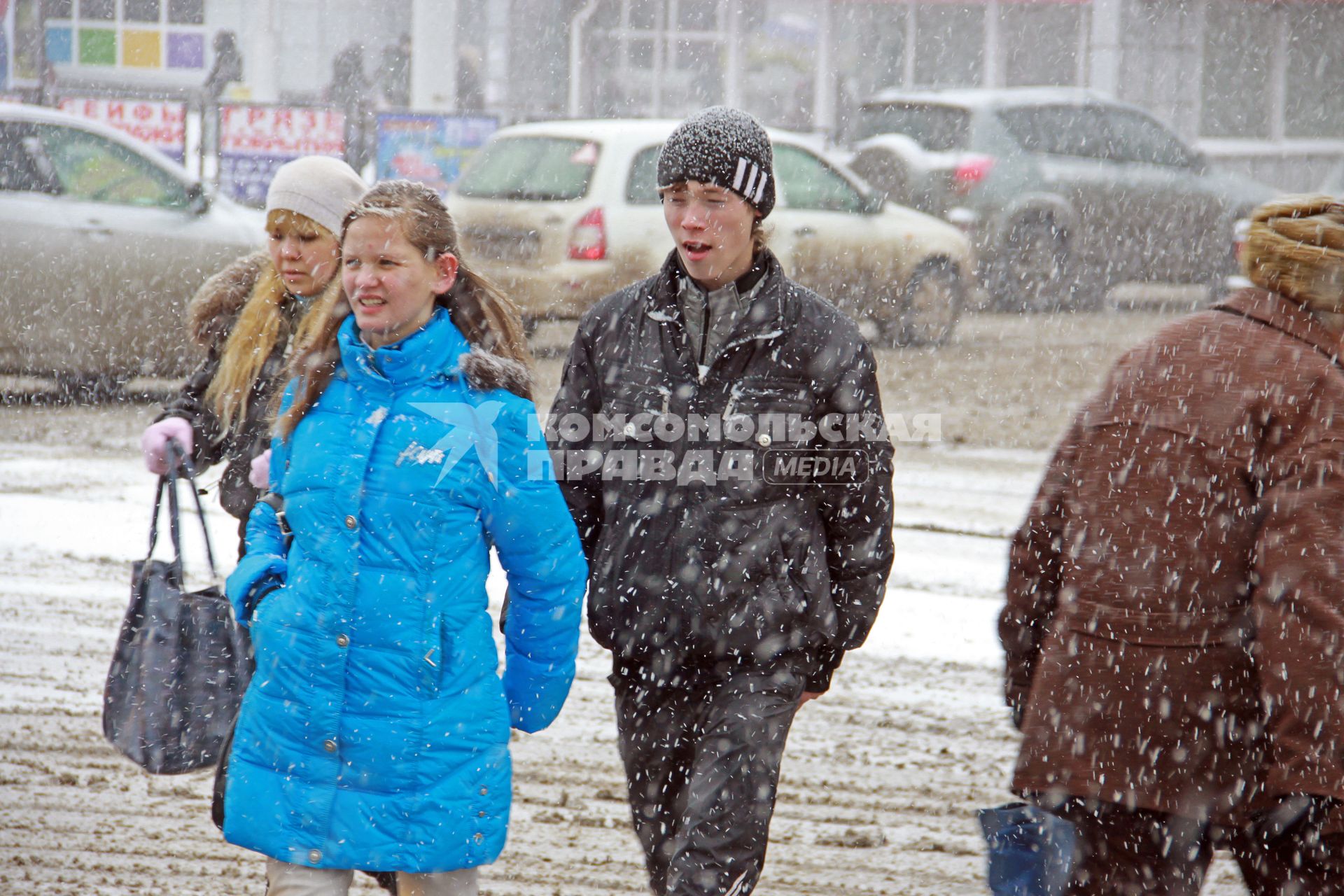 Люди в городе во время снегопада.