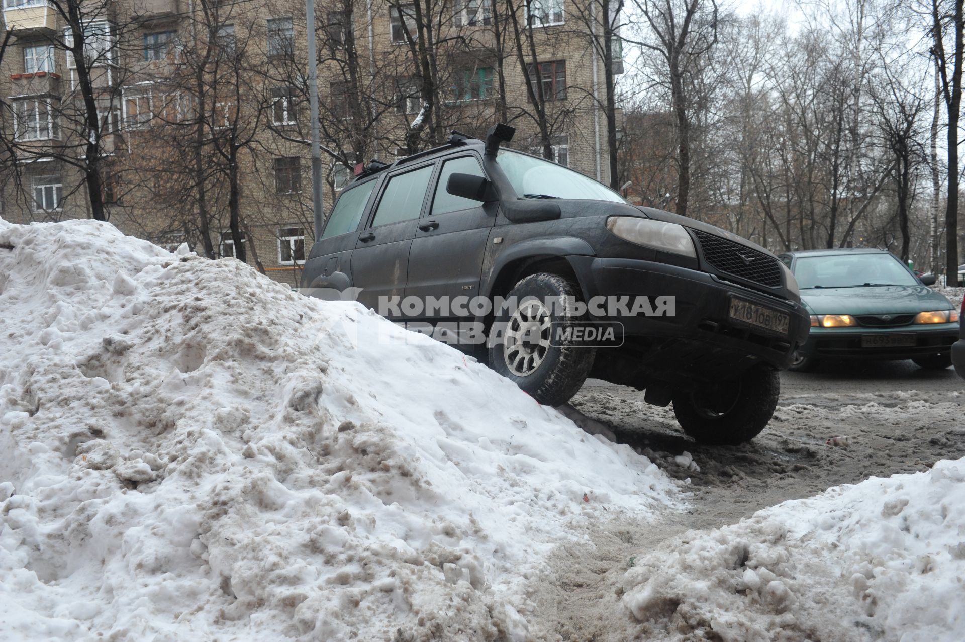 Припаркованный на сугробе автомобиль.