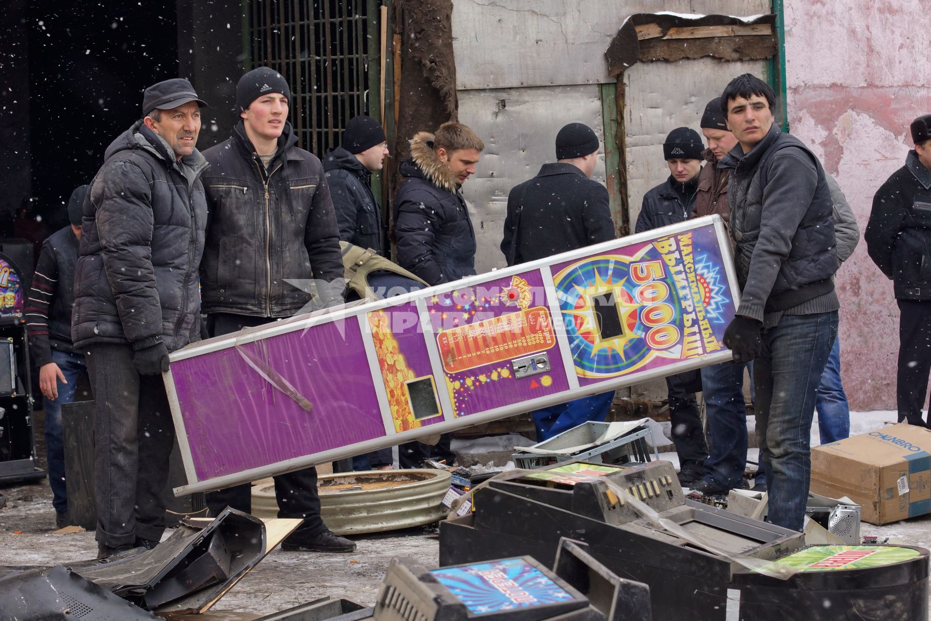 В Екатеринбурге уничтожают игровые автоматы. На снимке: рабочие несут игровой автомат.