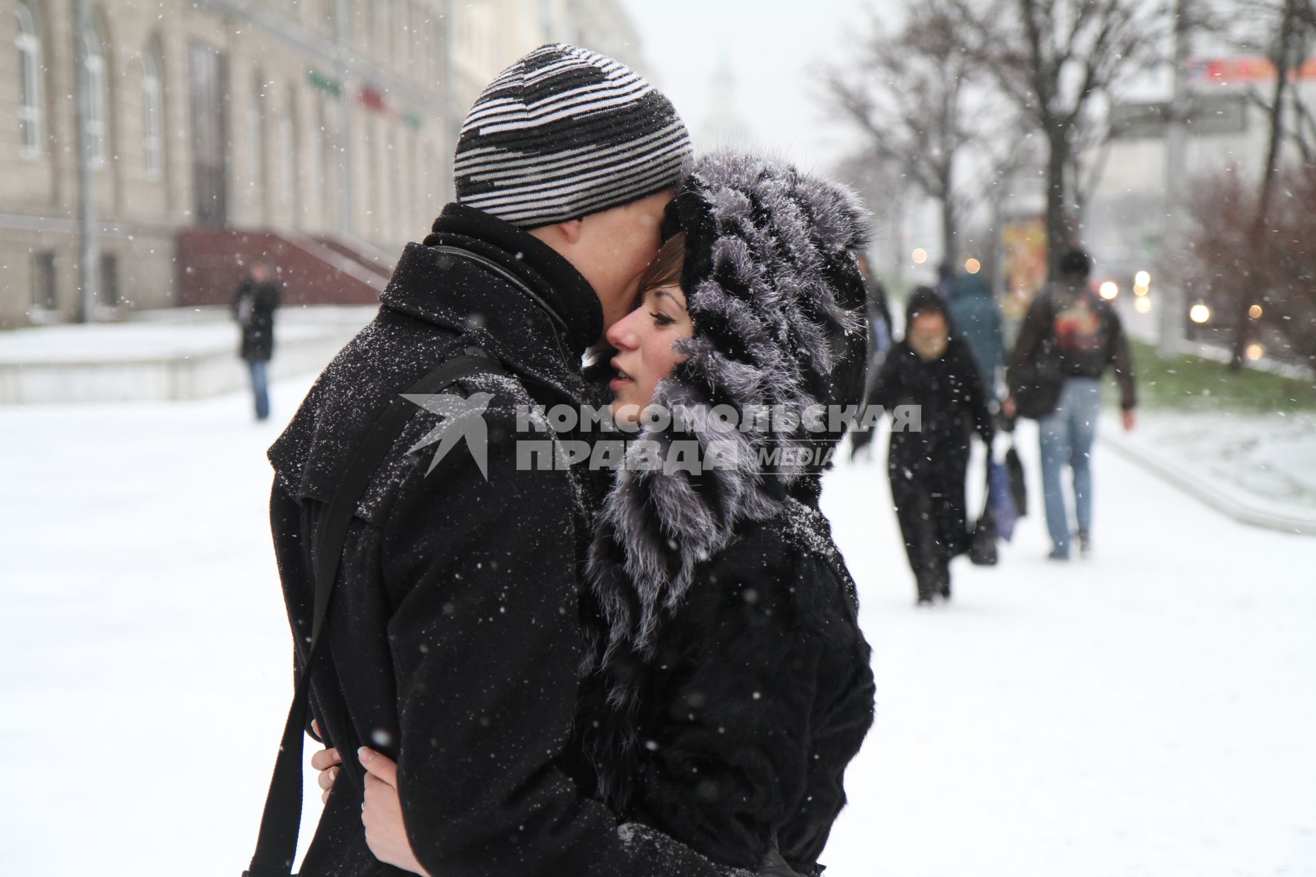 Парень с девушкой обнимаются на морозе.