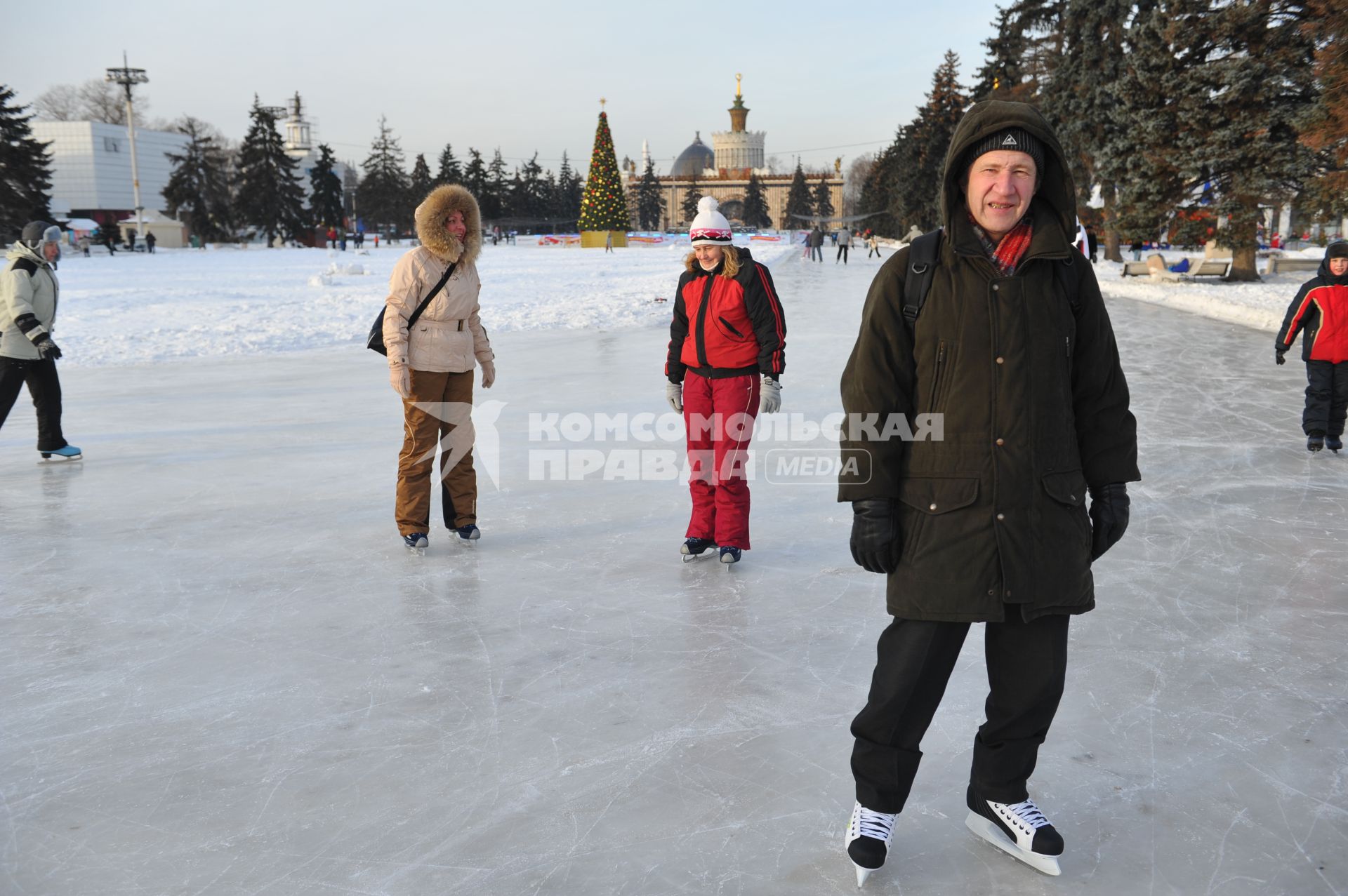 Бесплатный каток на ВВЦ. Люди катаются на коньках.