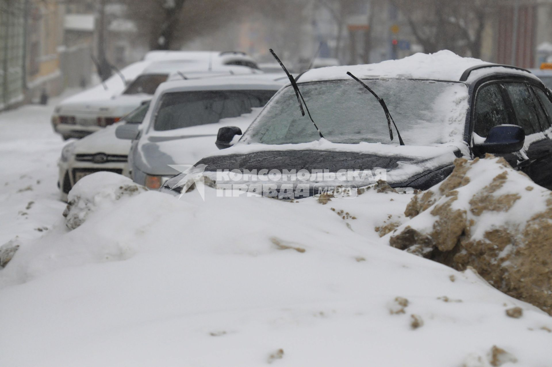 Последствия снегопада. На снимке: автомобильные дворники на заснеженной машине