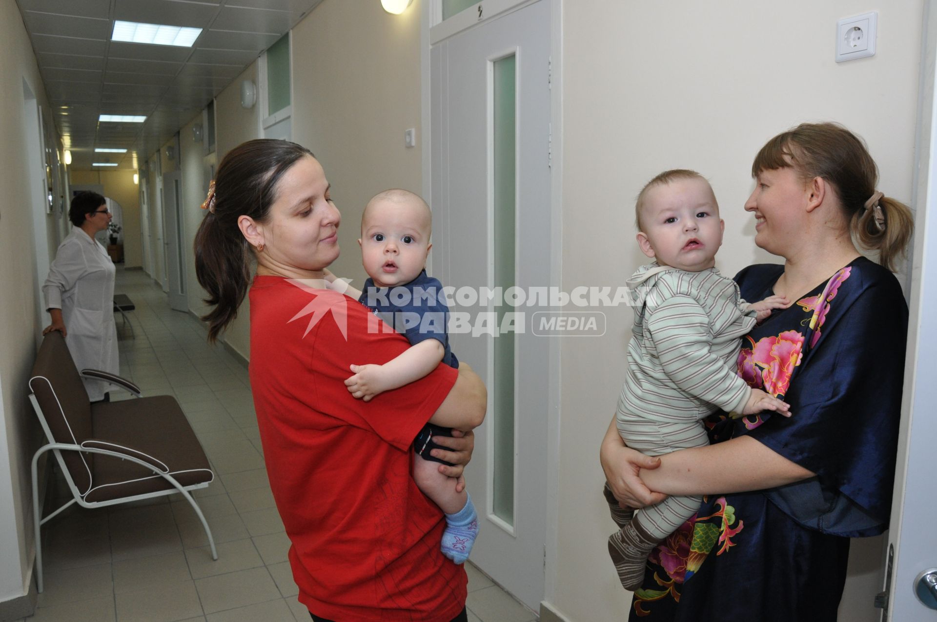 Мамы с детьми в коридоре больницы.