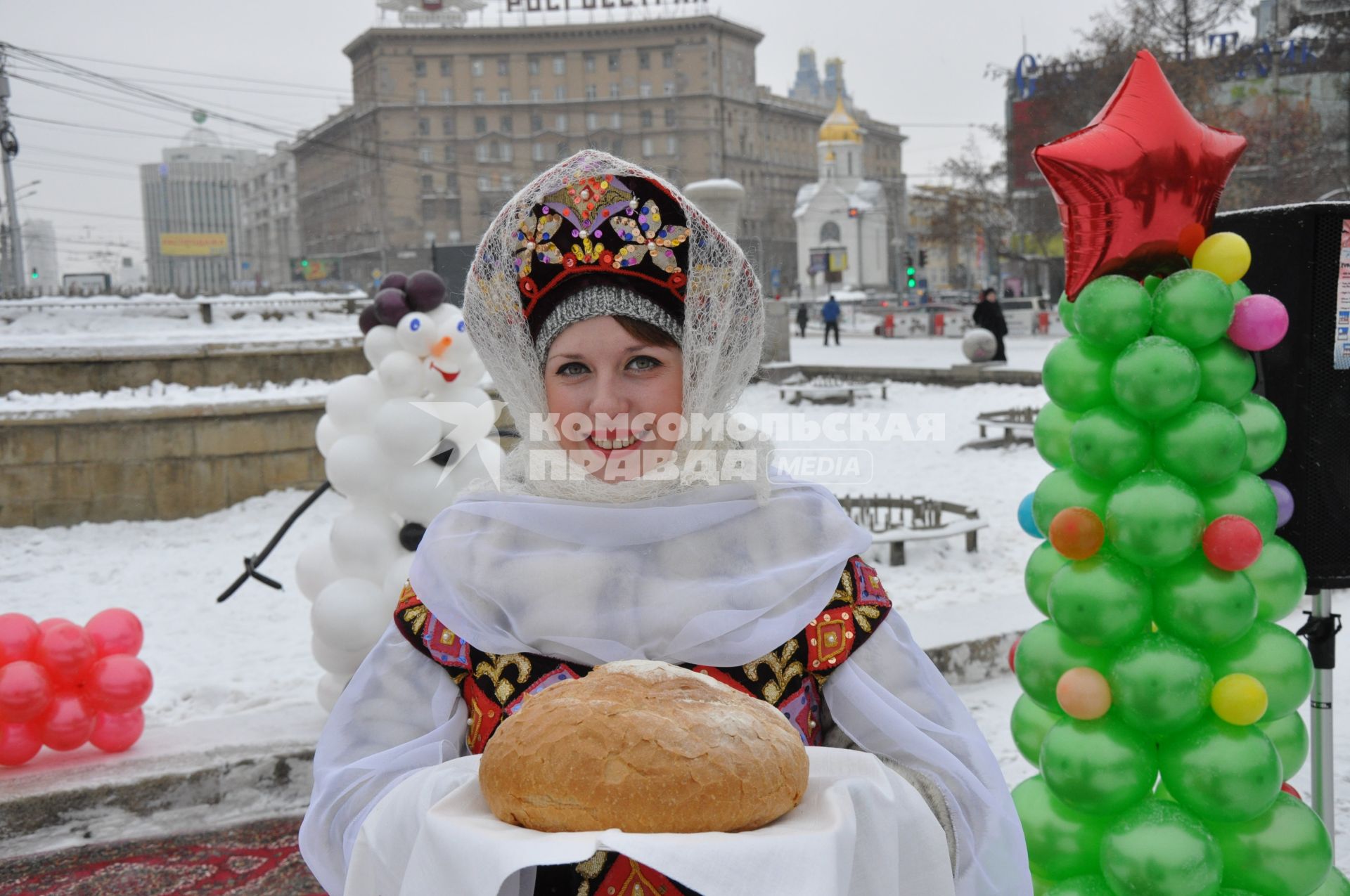 Женщина в кокошнике встречает караваем на открытие фестиваля снежных скульптур в Новосибирске.