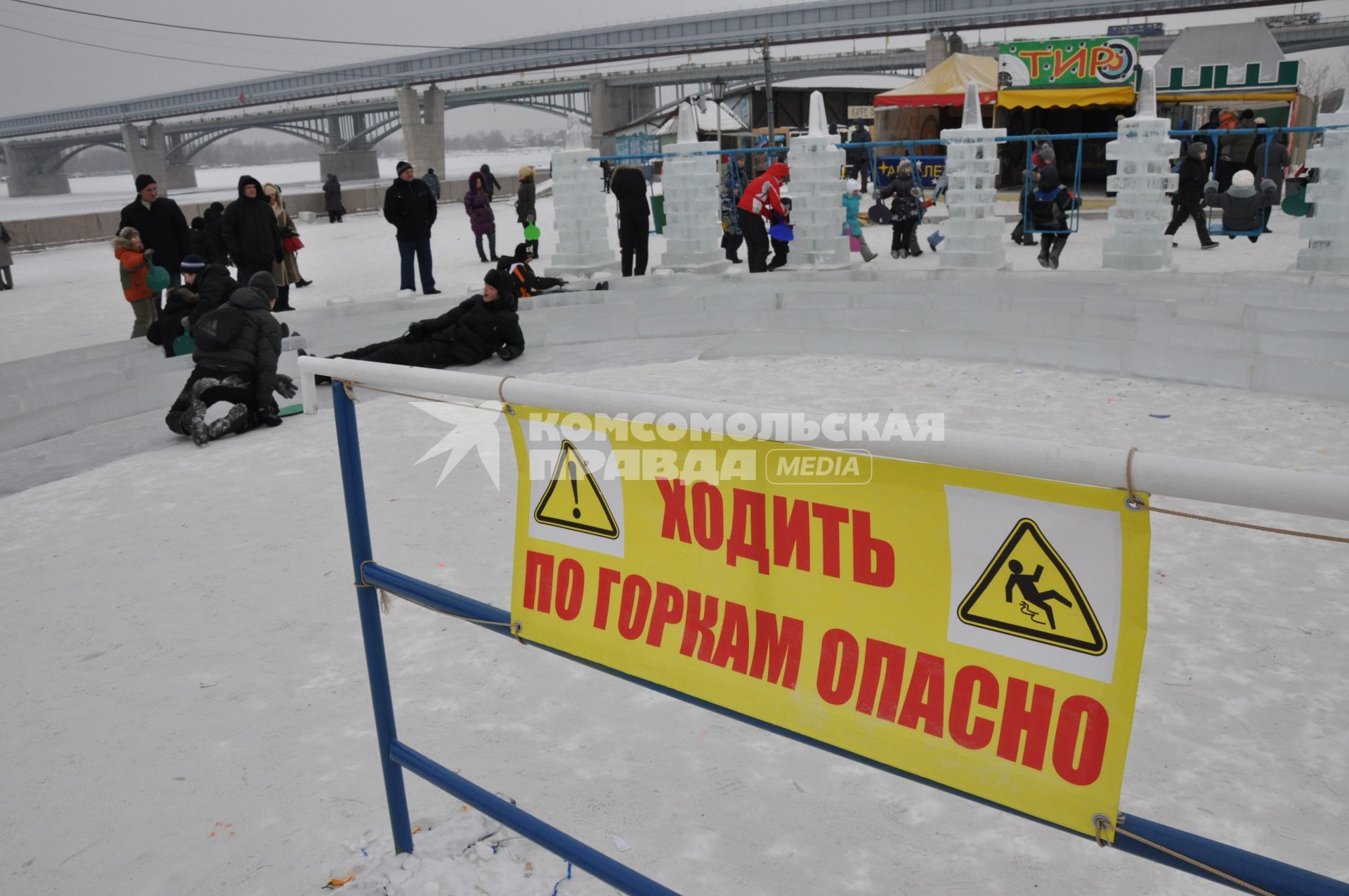 Заградительный плакат: `Ходить по горкам опасно` в ледовом городке.