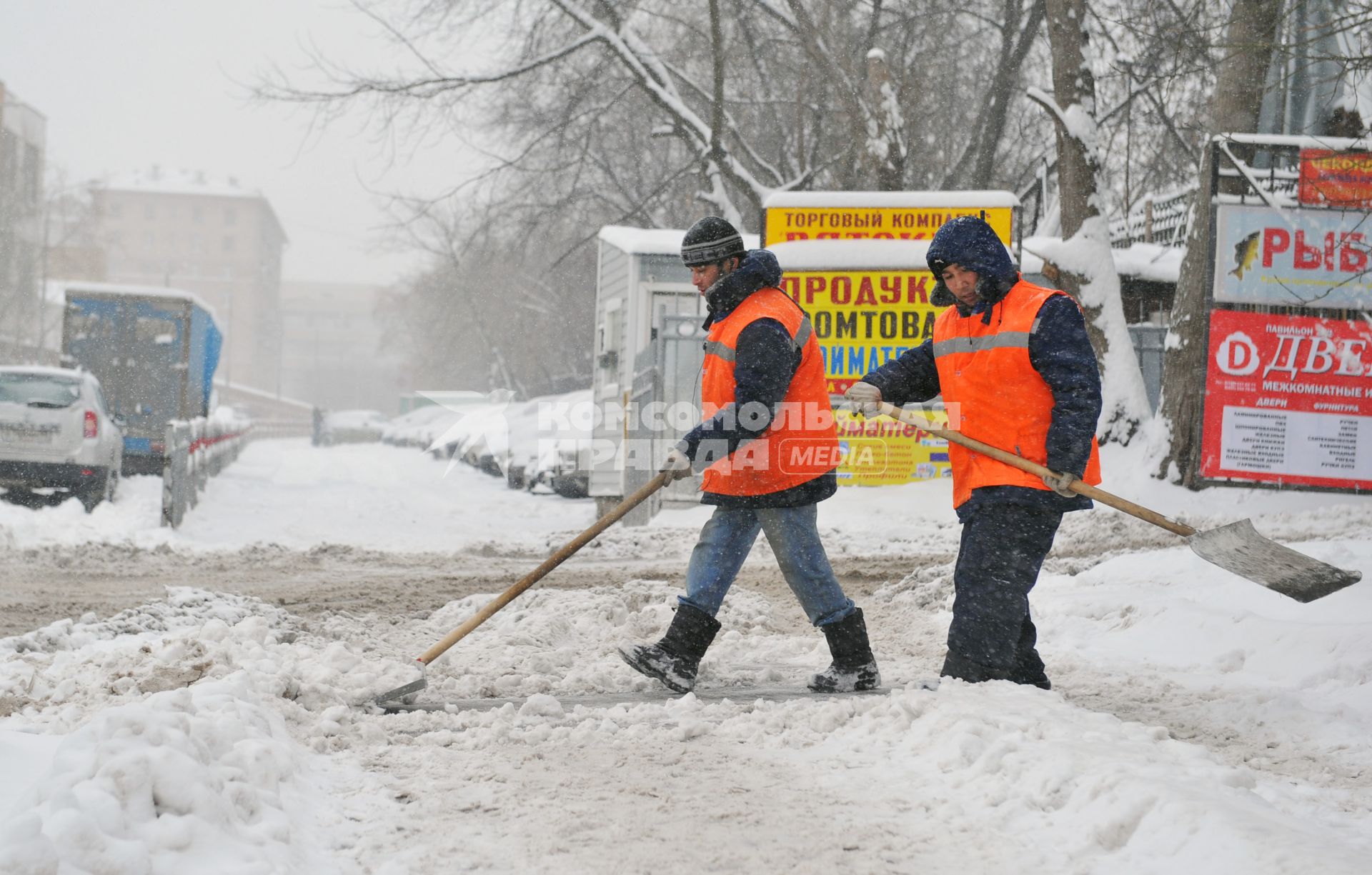 Дворники гастарбайтеры чистят улицу от снега.