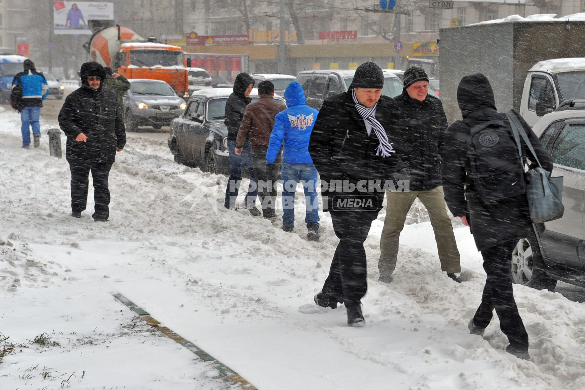 Прохожие на улице в сильный снегопад.