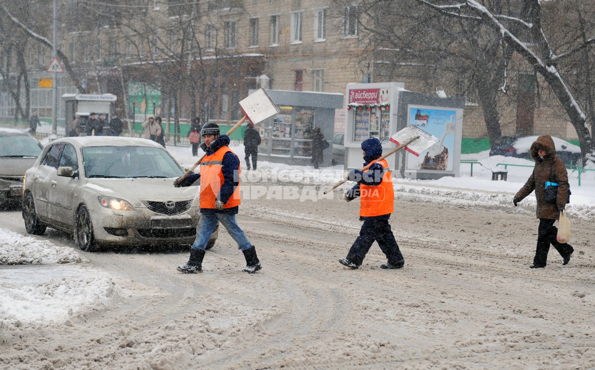 Дворники с лопатами переходят улицу.