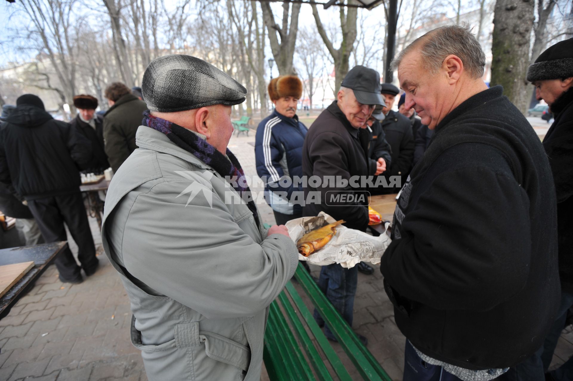 Одесса. На снимке: мужчина угощает приятелей рыбой.