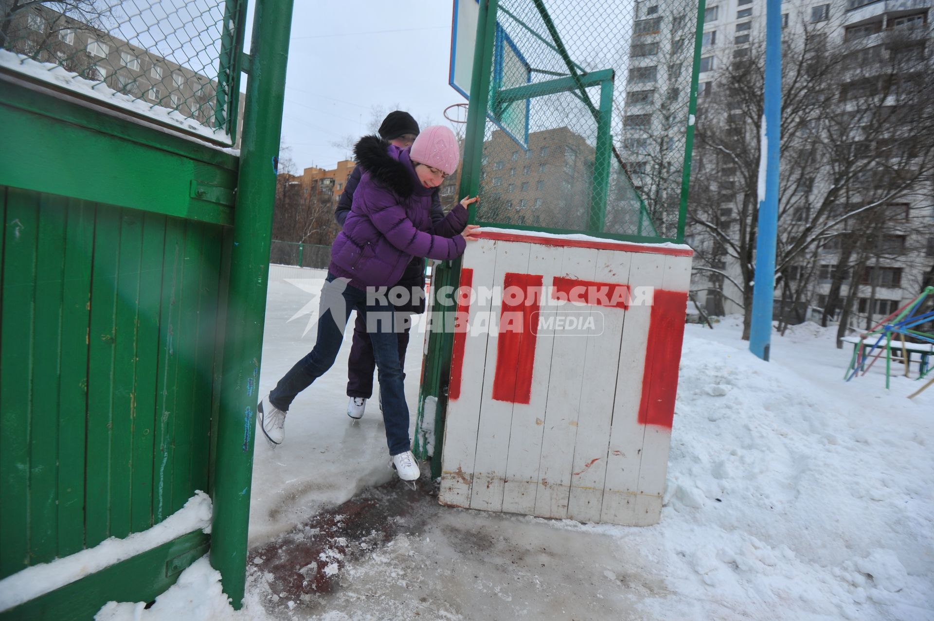 Хоккейная коробка во дворе дома. На снимке: девочки катаются на коньках