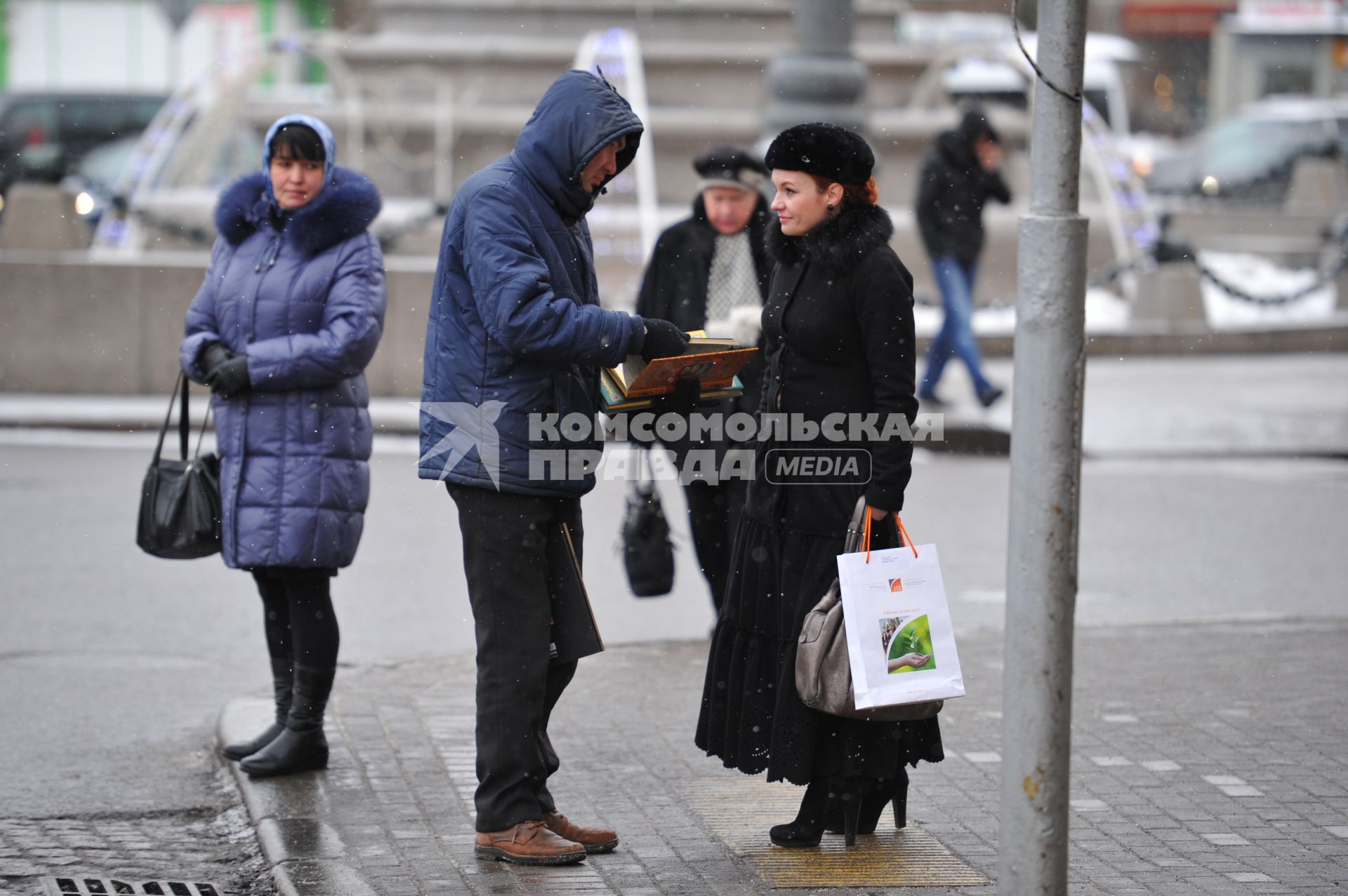 Мужчина продает книги прохожим.