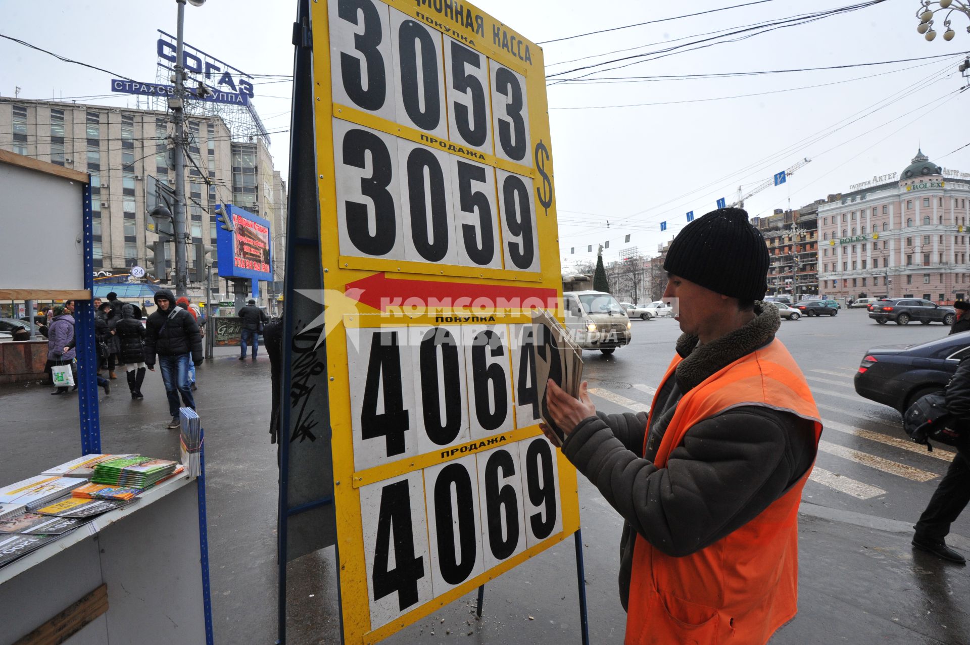 Мужчина меняет курс валюты на табло.