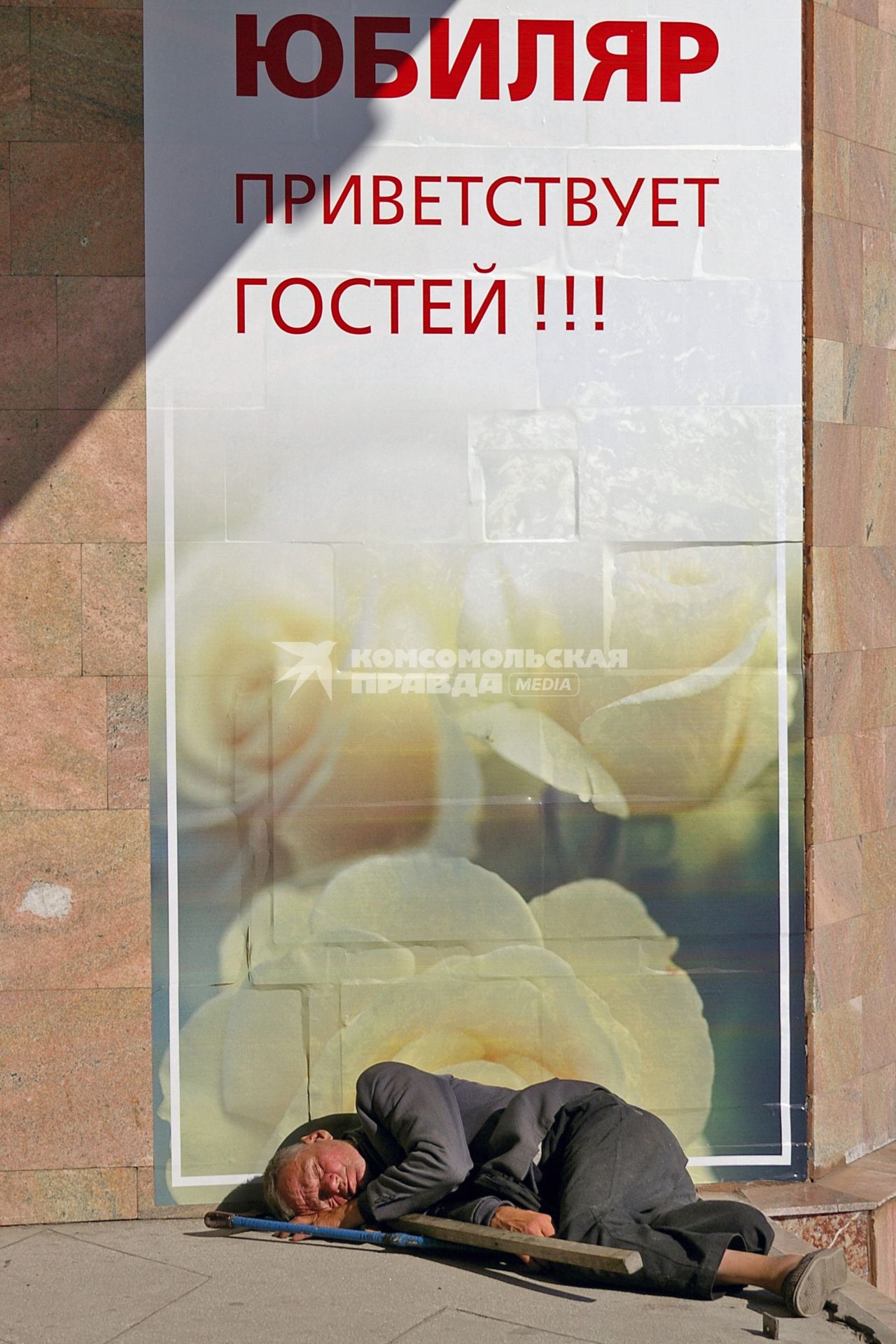 Бомж уснул на улице у плаката: `Юбиляр приветствует гостей!`