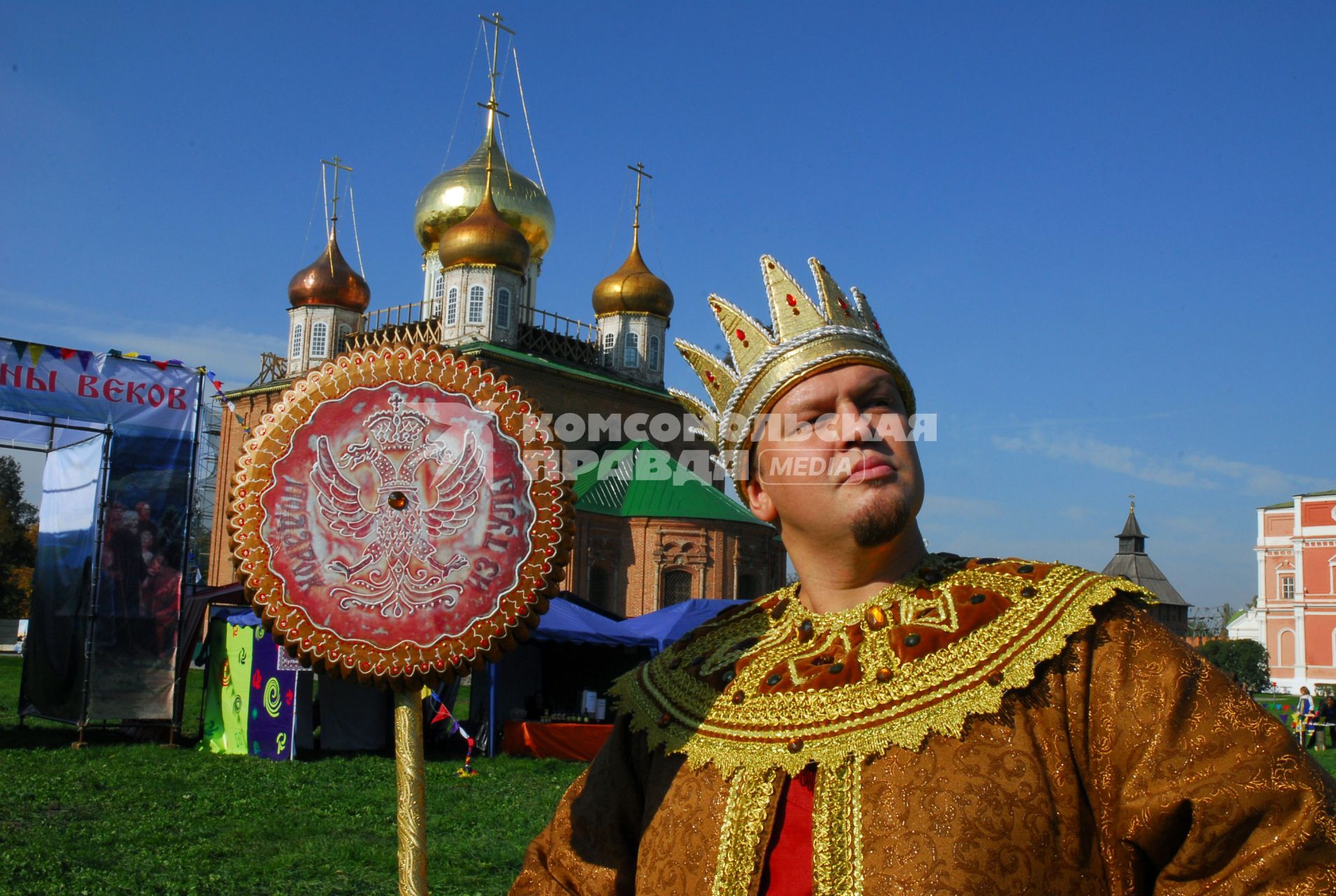 Мужчина в костюме царя, в короне, со скипетром в виде тульского пряника, на фоне православного храма.