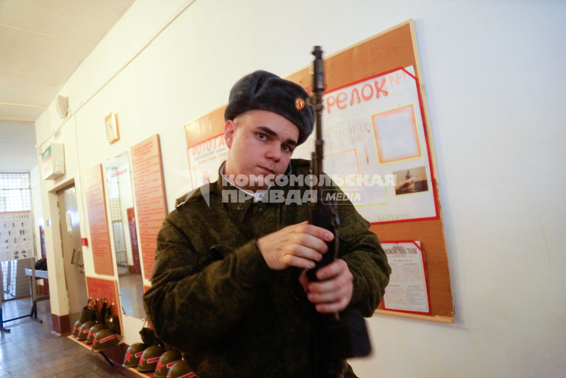 В Еланском военном гарнизоне к воинской присяге привели молодое пополнение. На снимке: солдат в казарме с оружием в руках разговаривает по мобильному телефону.