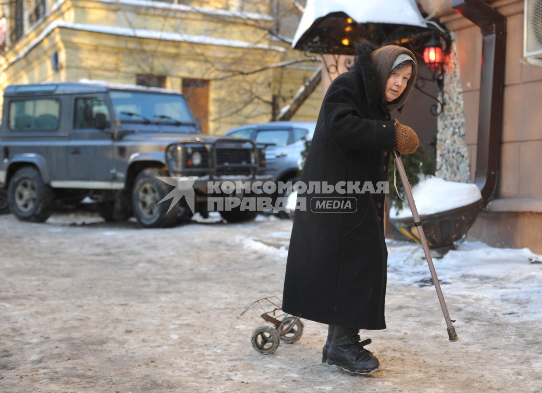 Пожилая женщина с палочкой.