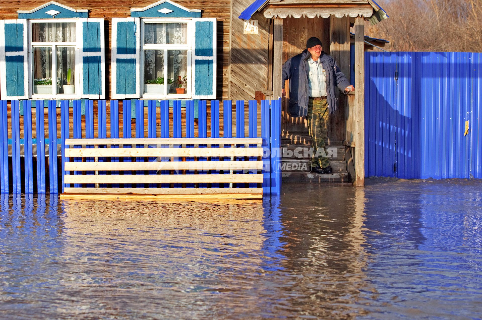 Весенним паводком затопило деревню в Самарской области. На снимке: Мужчина стоит на пороге деревенского дома, вода подступила к крыльцу.