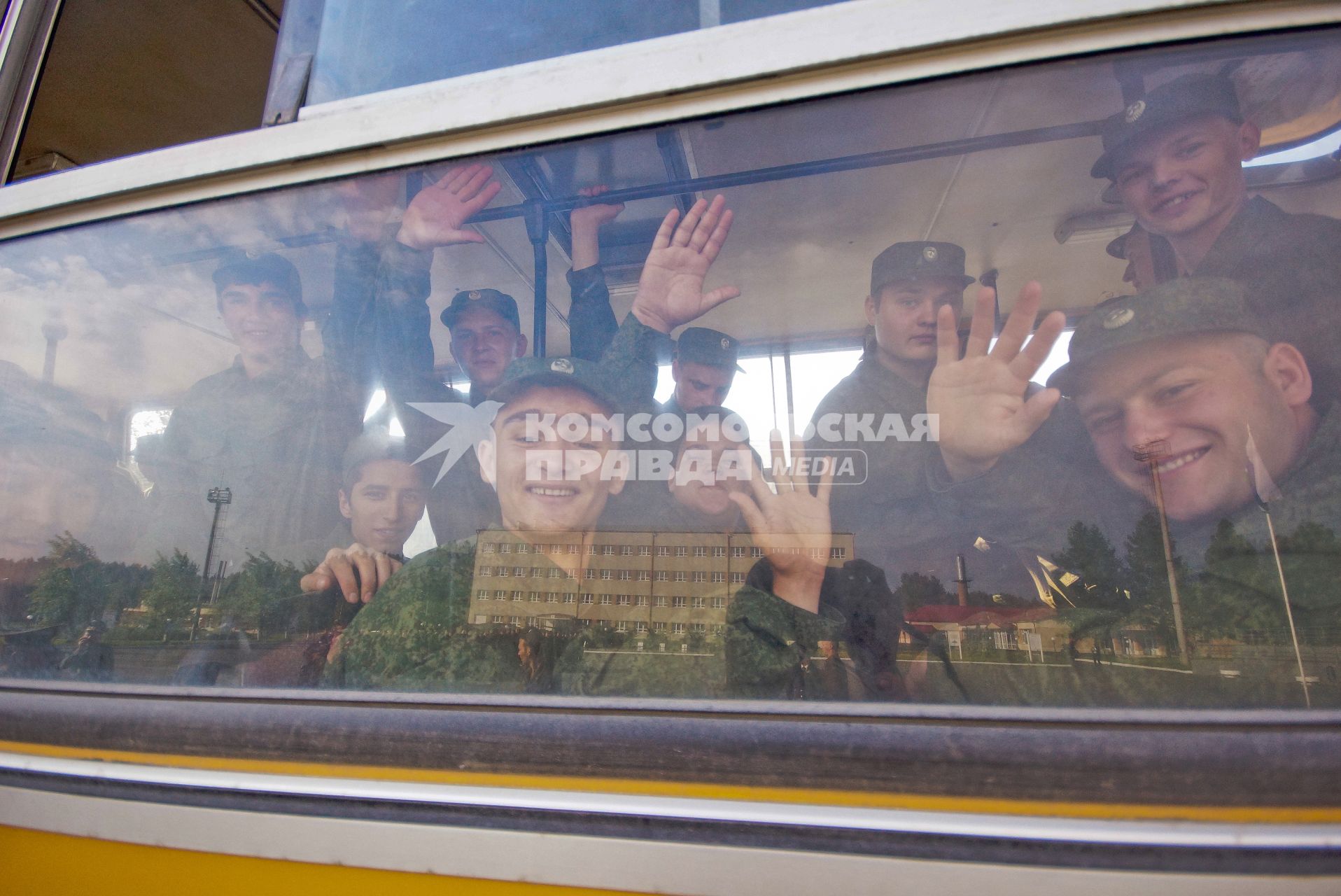 Призывники смотрят из окна автобуса.