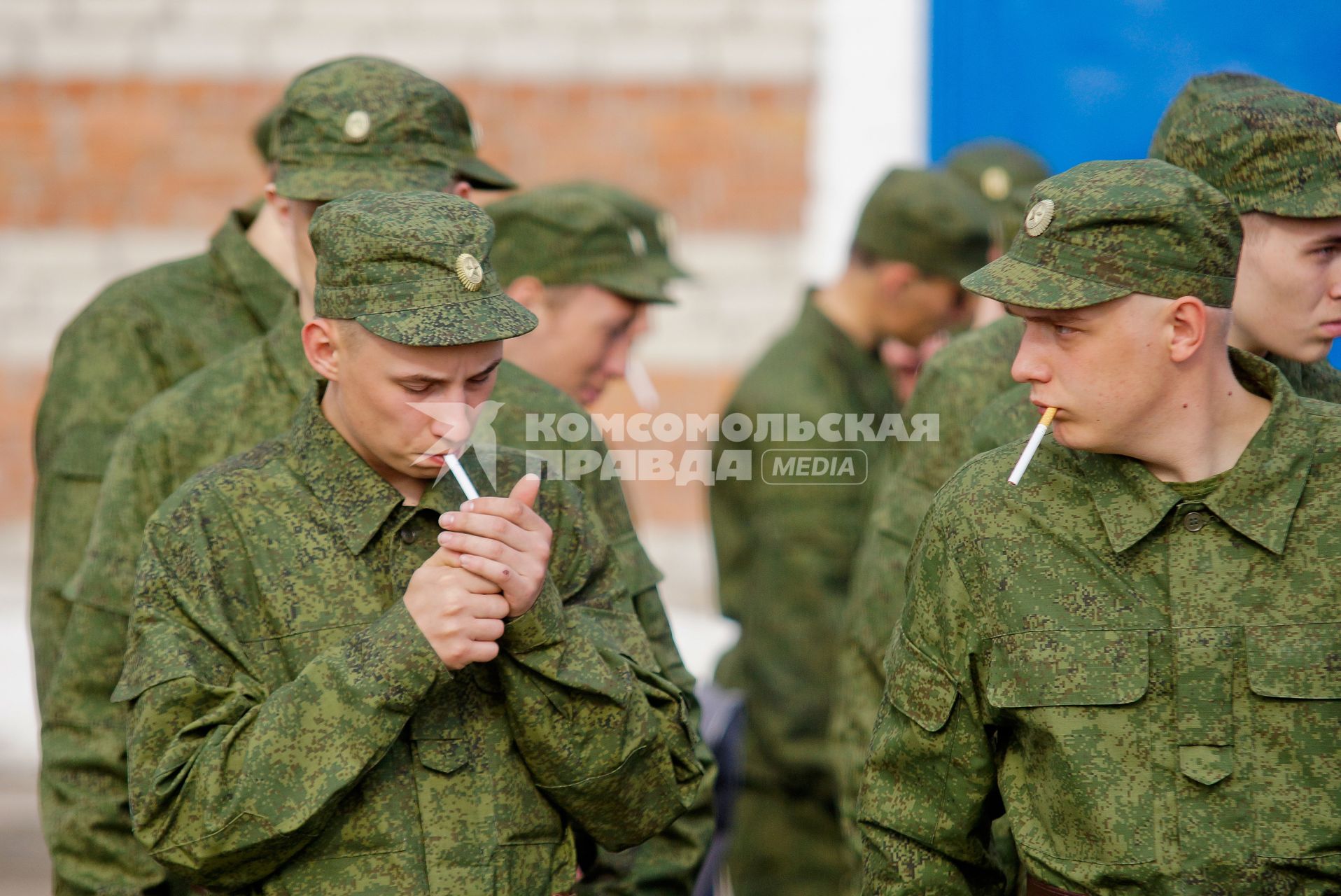 Призывники курят сигареты перед отправкой в войска.