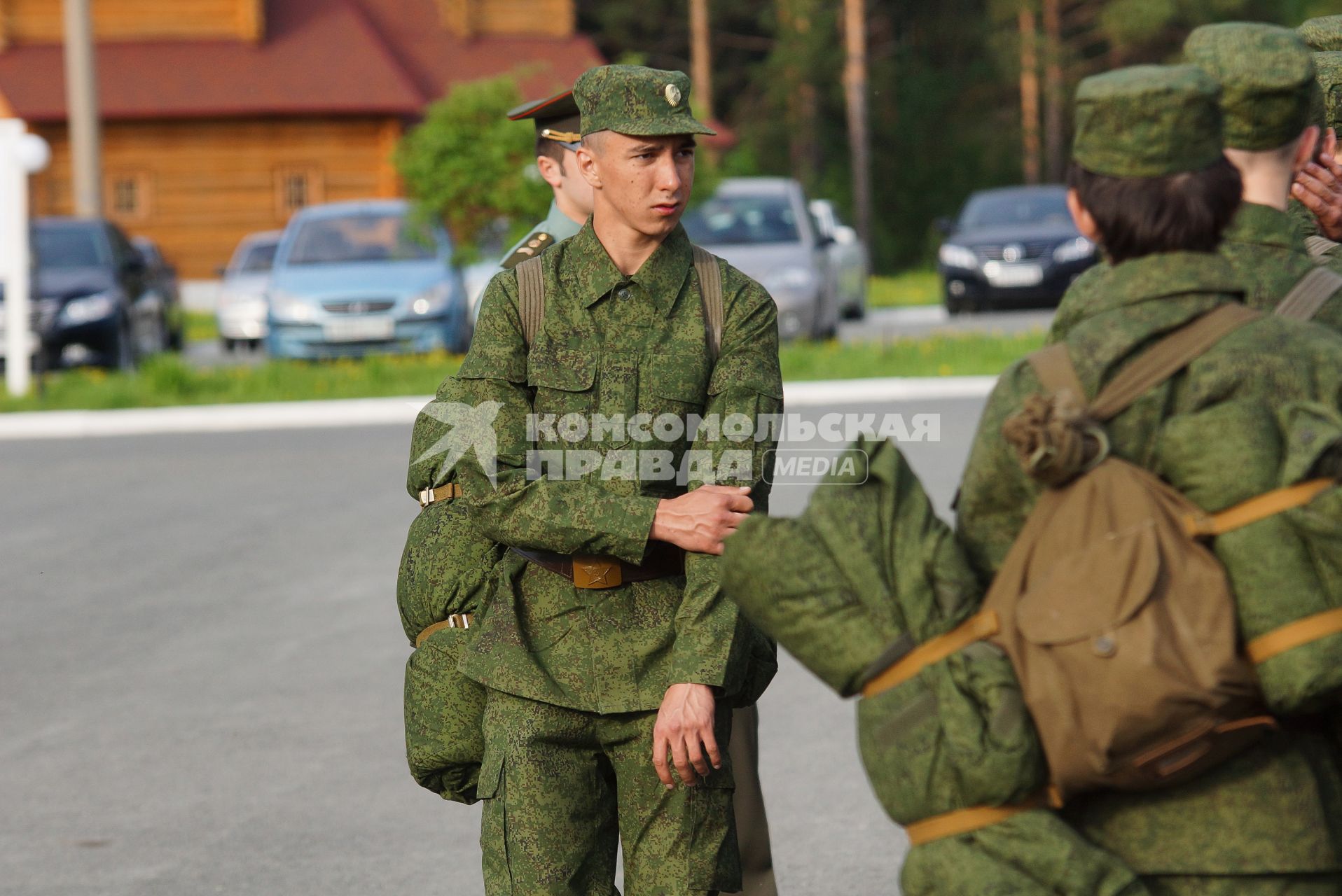 Призывник стоит на плацу у строя новобранцев.