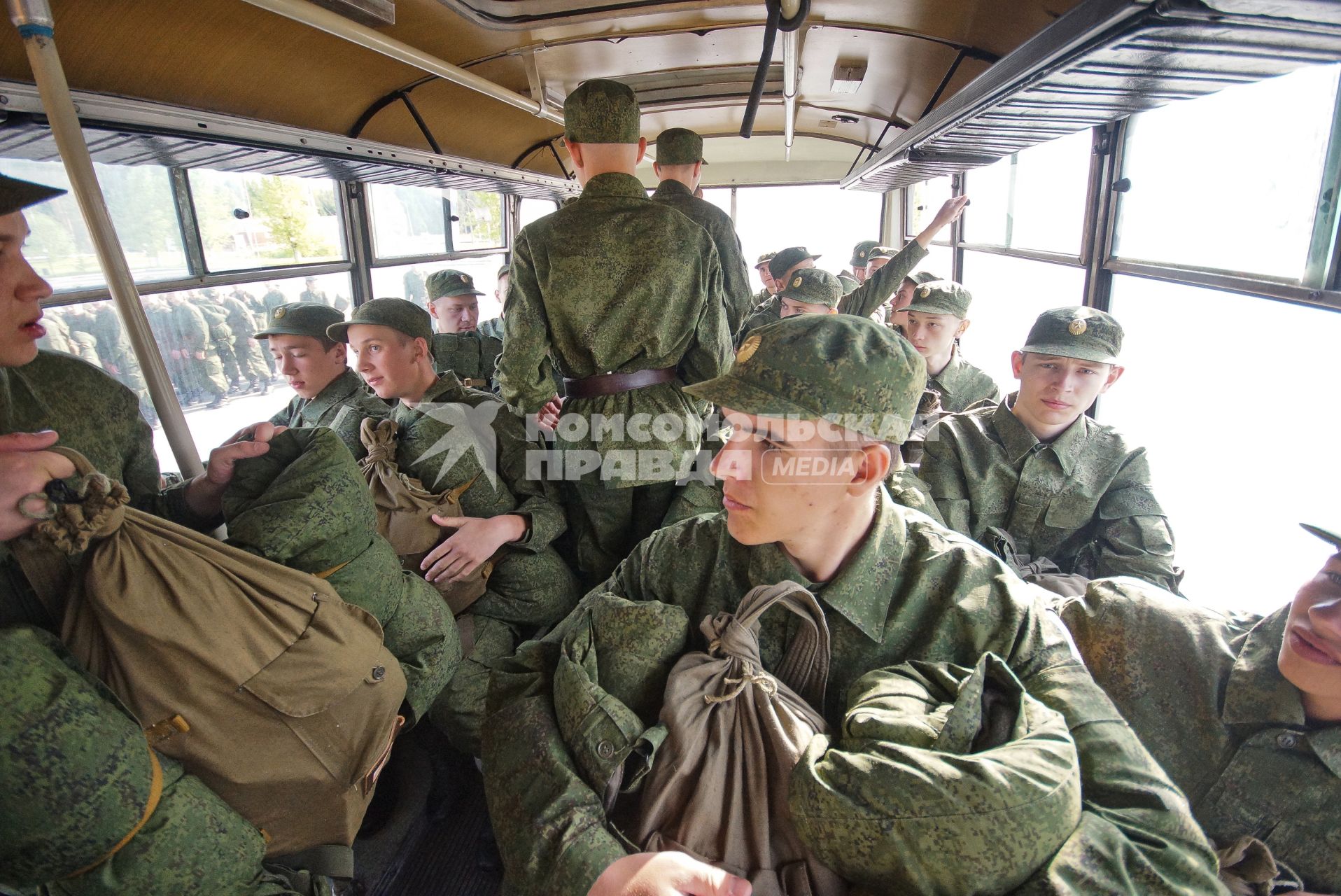 Призывники рассаживаются в автобусе.