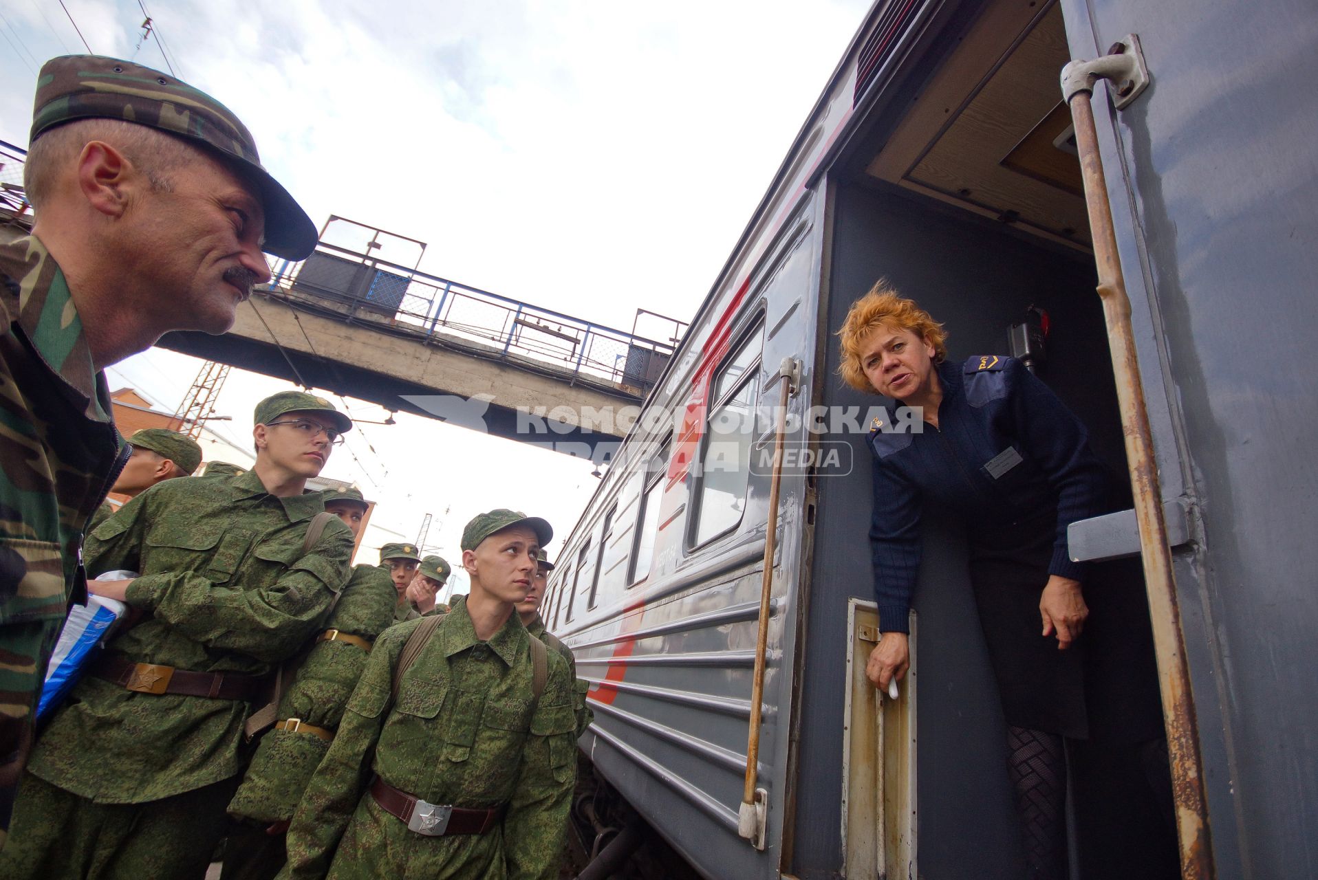 Проводница встречает колонну солдат.