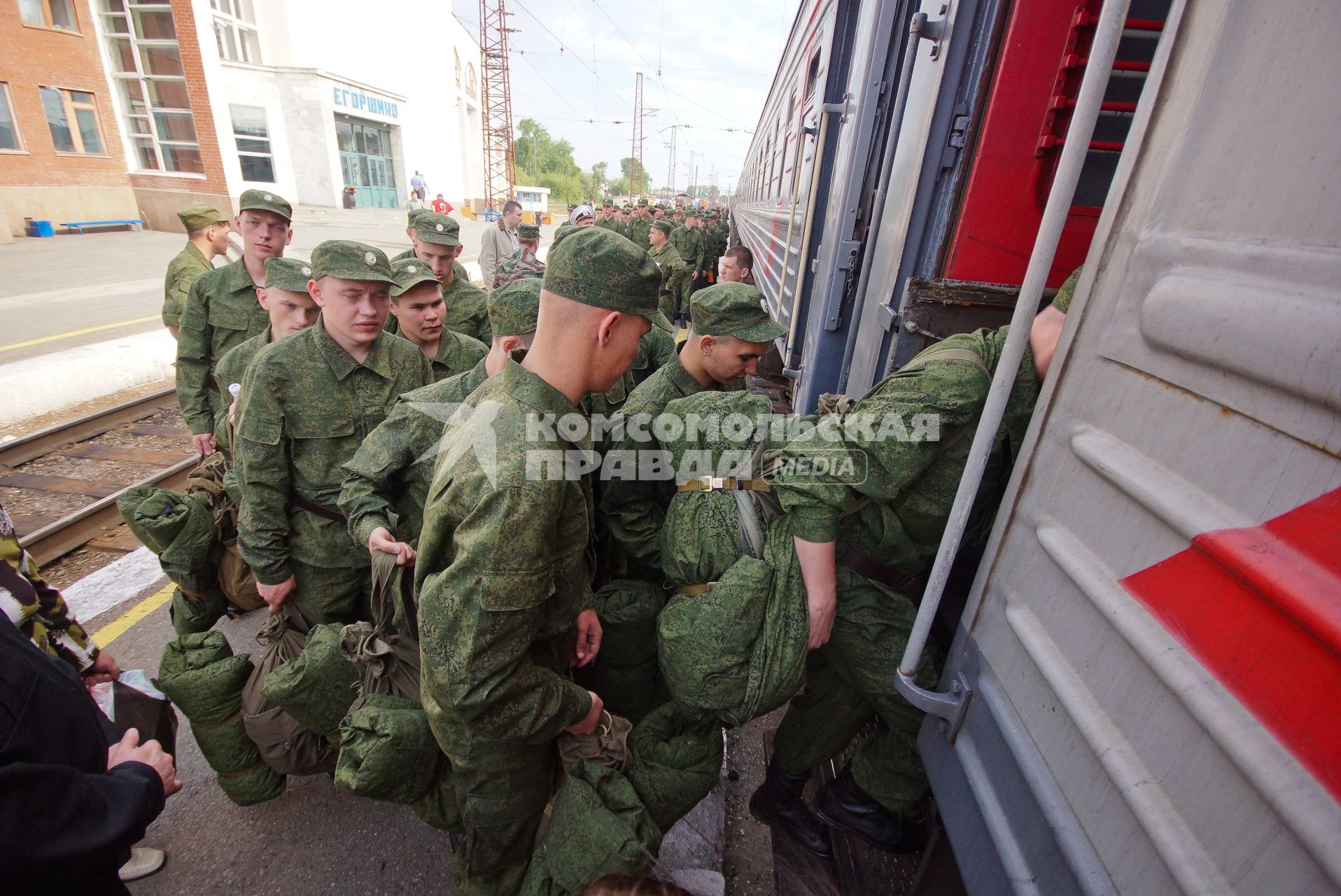 Солдаты поднимаются в вагон поезда.