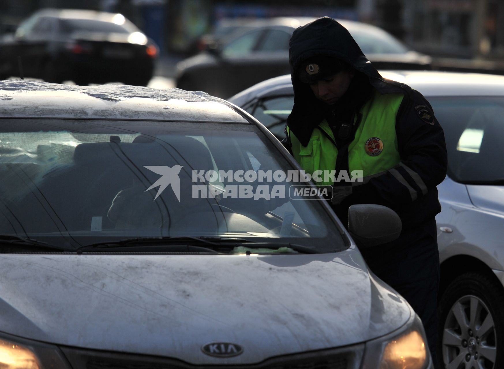 Сотрудник ДПС проверяет документы у водителя автомобиля.