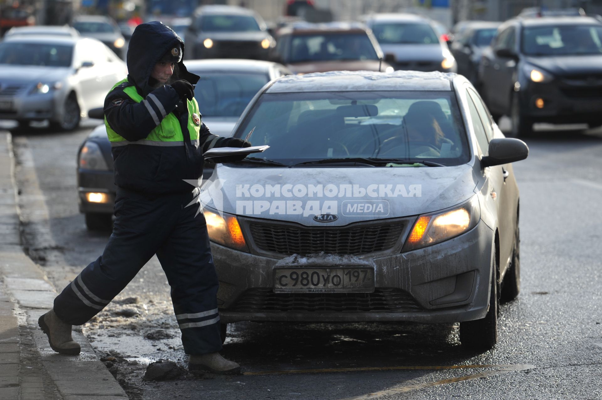 Сотрудник ДПС останавливает водителей автомобилей для проверки документов
