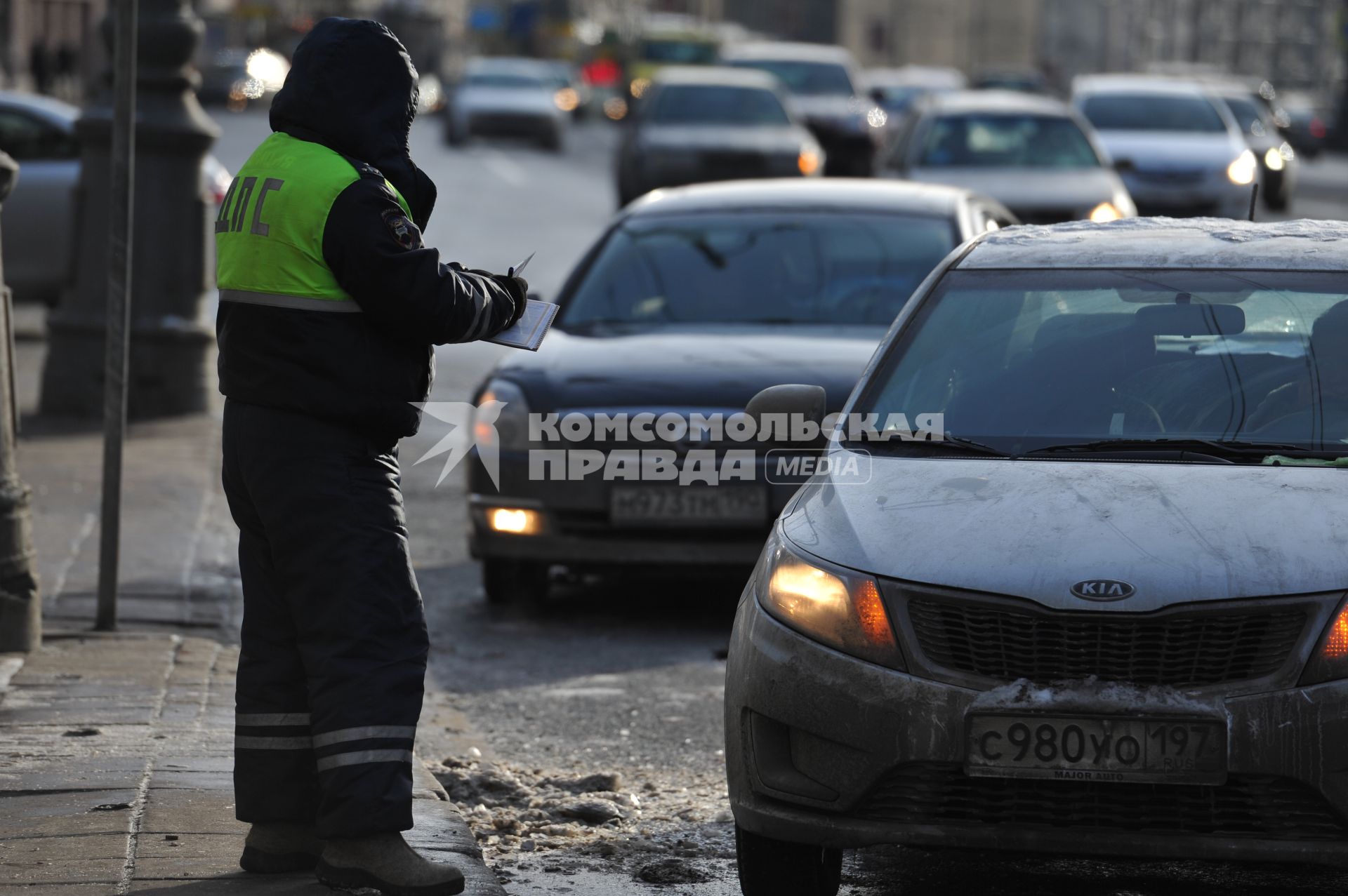 Сотрудник ДПС останавливает водителей автомобилей для проверки документов