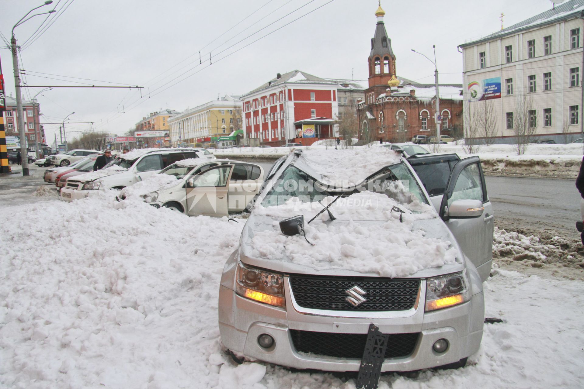 Снежная лавина обрушилась с крыши дома на тротуар и припаркованные автомобили в Барнауле. На снимке: поврежденный автомобиль засыпанный снегом.