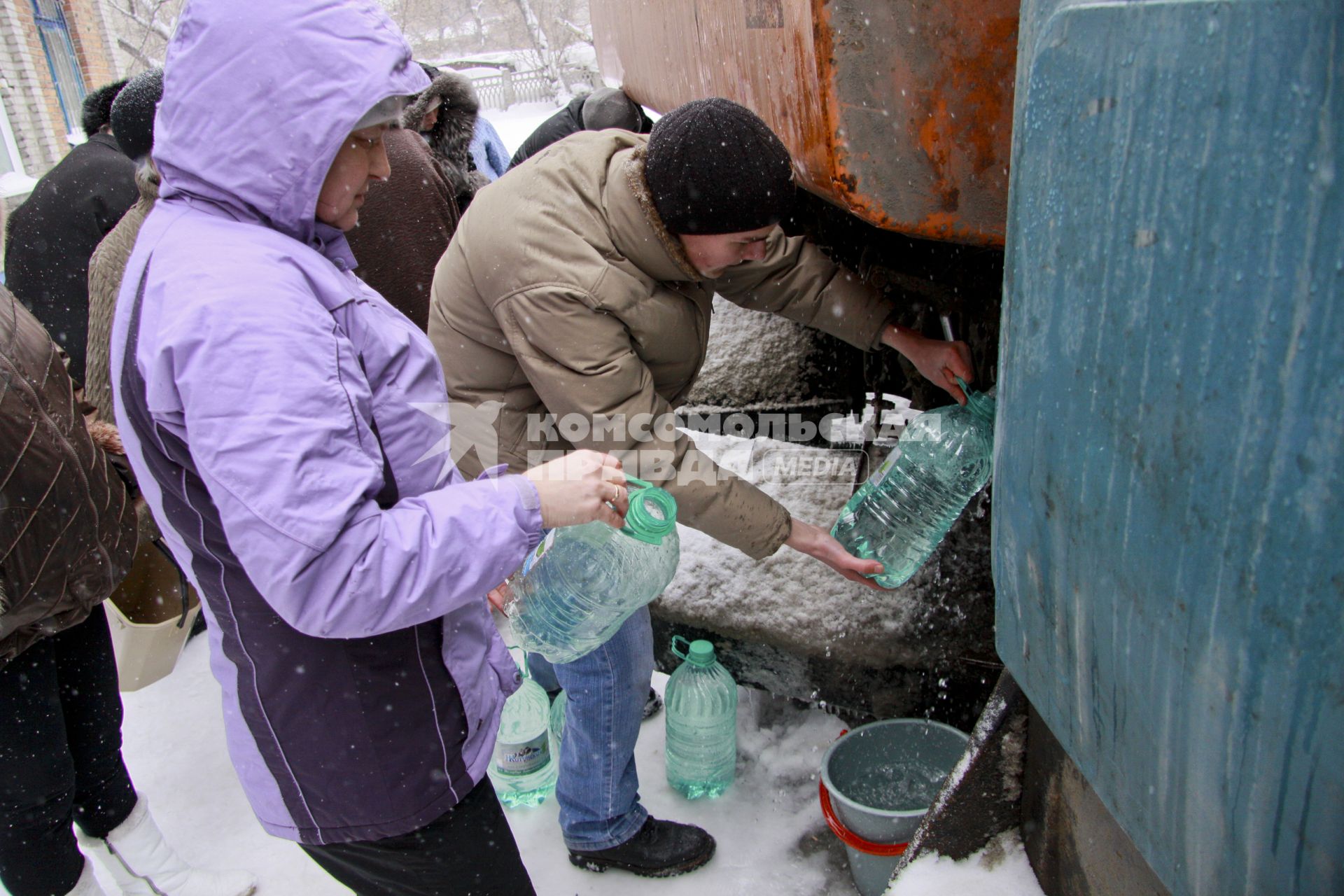 Аварийное отключение воды. На снимке: люди наполняют бутылки водой из поливочной машины.