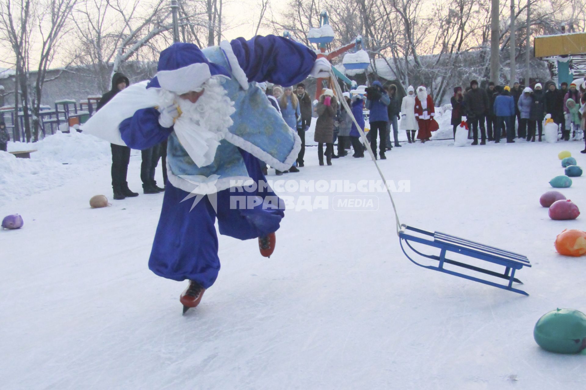 Забег Дедов Морозов на коньках. Дед Мороз на коньках несет мешок с подарками и тащит за собой санки.