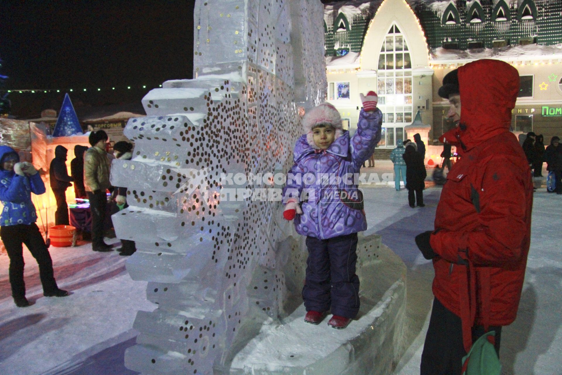 Празднование старого нового года на улицах Барнаула. Жители города закрепляют монетки на ледяных скульптурах на счастье.