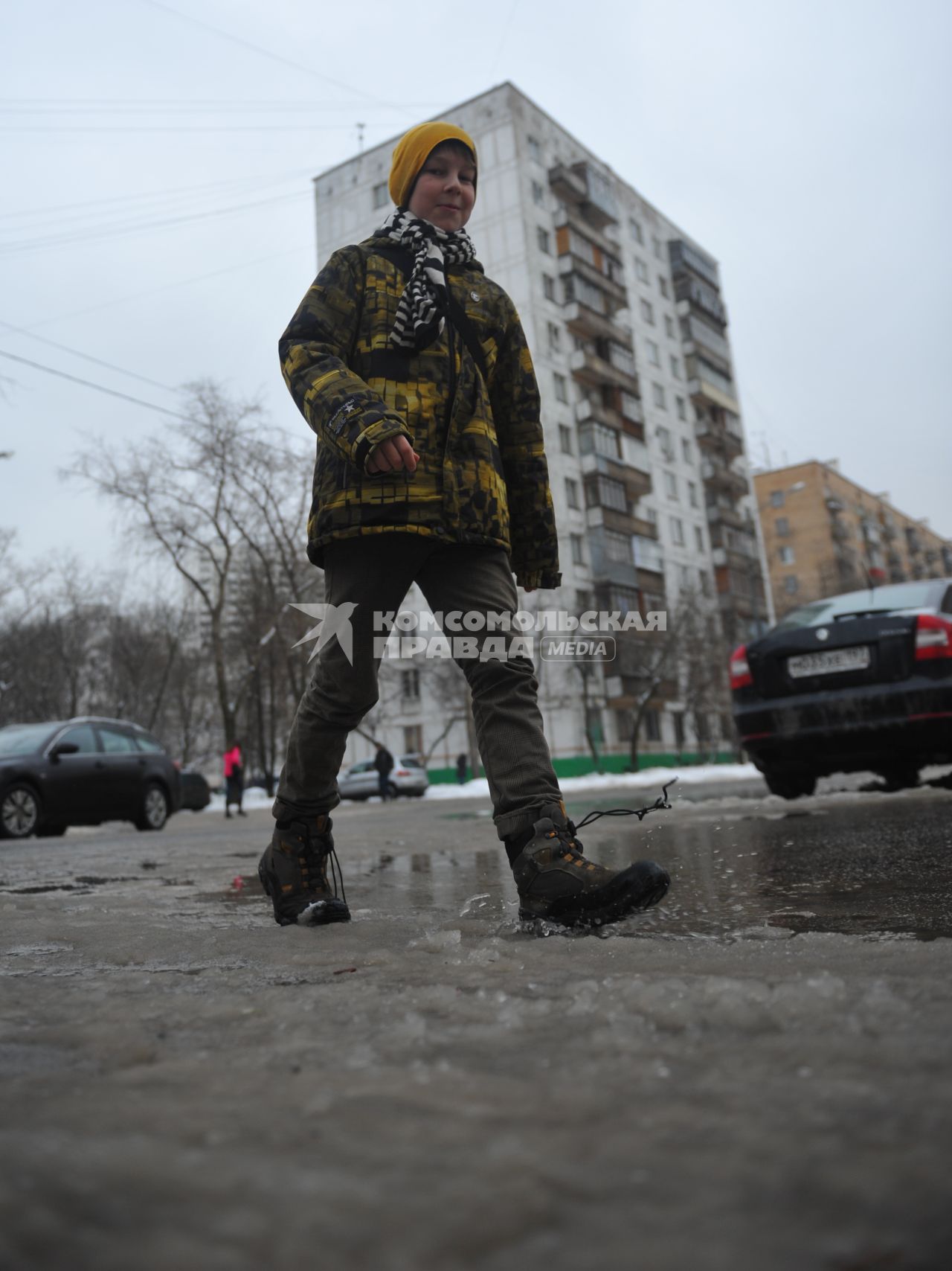 Подросток идет по лужам