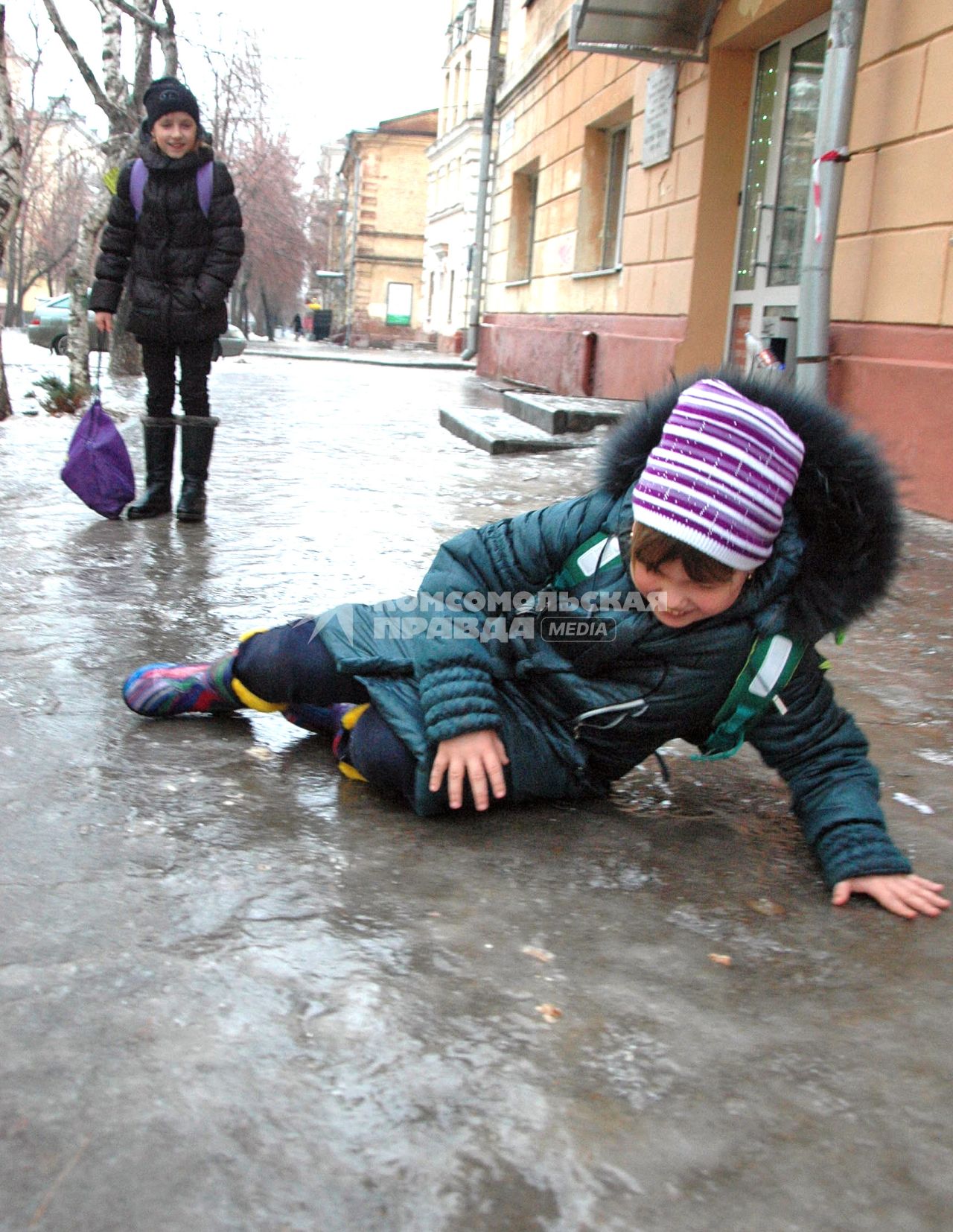 „евочка упала на заледеневшем тротуаре.