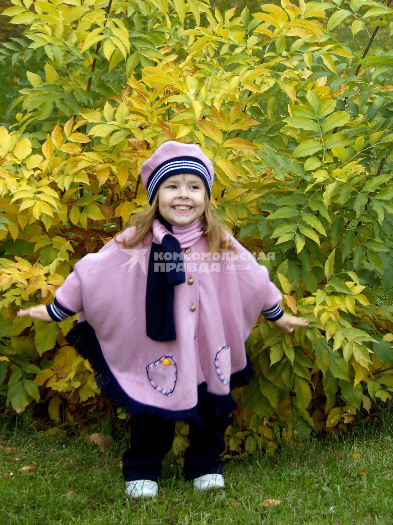 Ребенок около куста с пожелтевшей листвой.