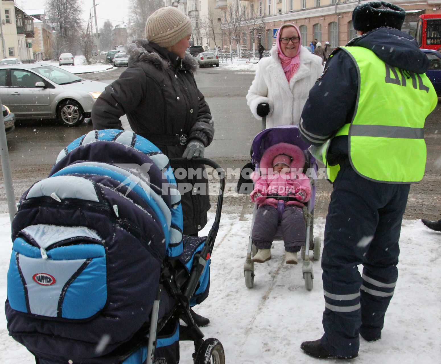 Сотрудники ГИБДД помогают переходить улицу.